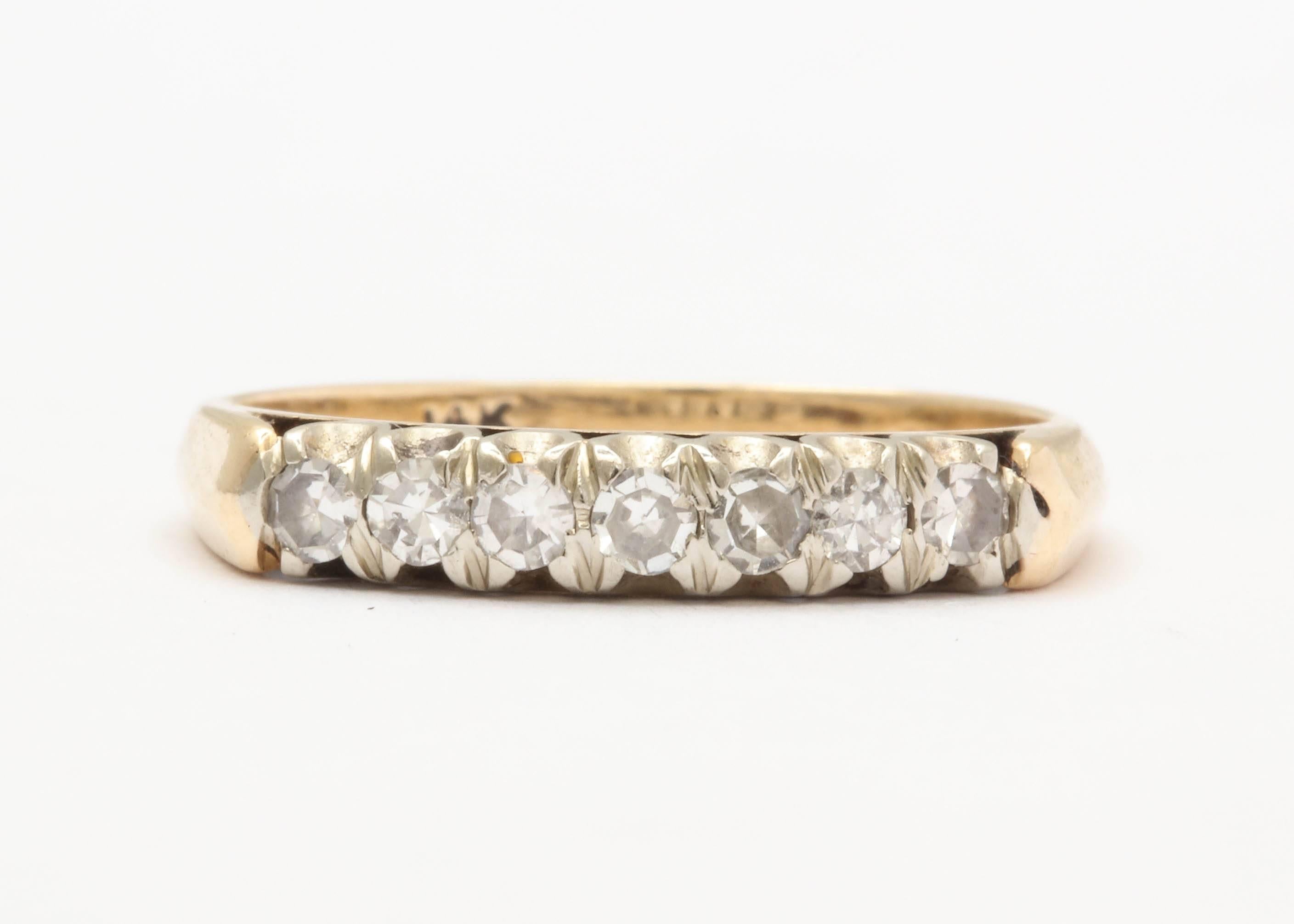 7 Diamonds are set in white gold atop a yellow gold band in this simple and pretty setting. Easy to wear as flat on the sides- perfect for stacking! Approximately .40-.45 total carat weight. 