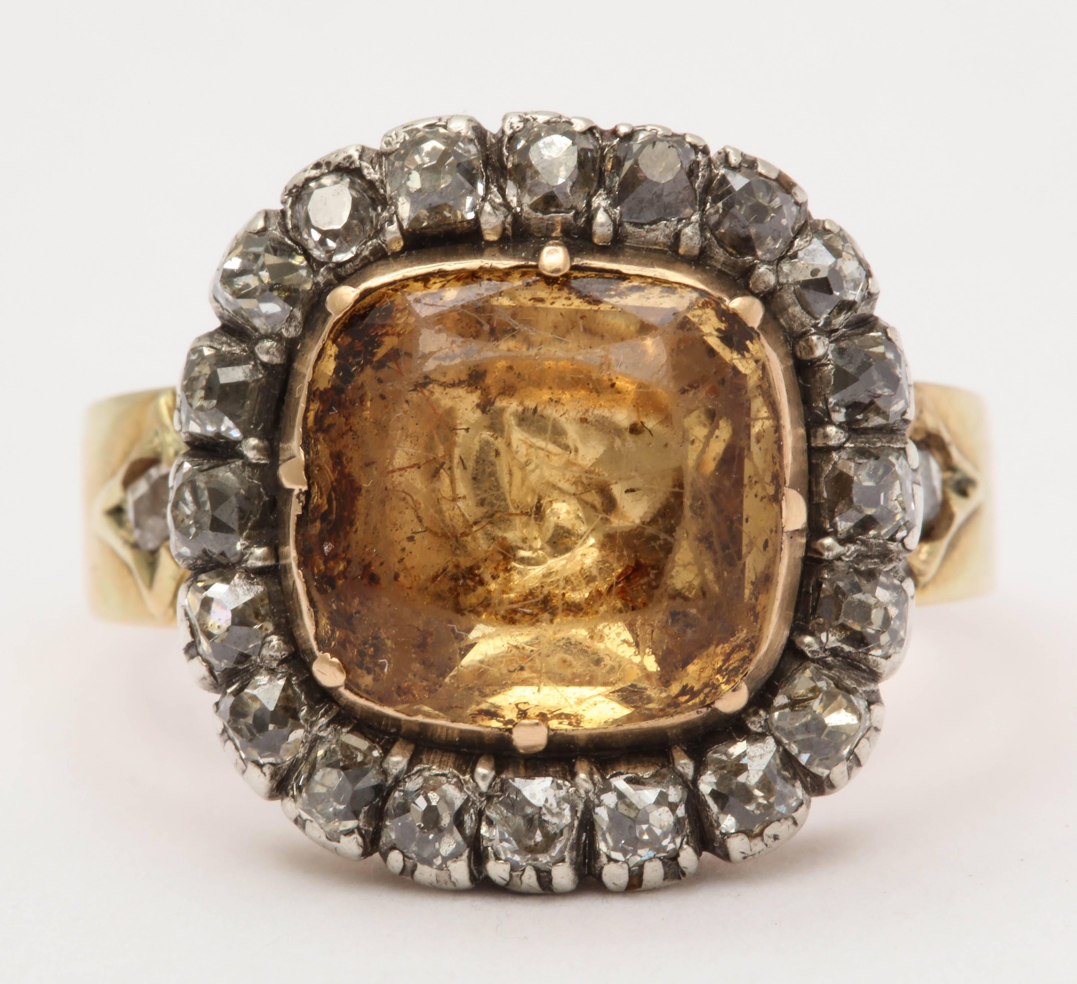 This incredible Georgian ring is centered with a large yellow topaz surrounded by diamonds all in closed back settings. The shank, fully hallmarked, indicates the ring was made in Birmingham England in 1816. It is set with a small diamond on either