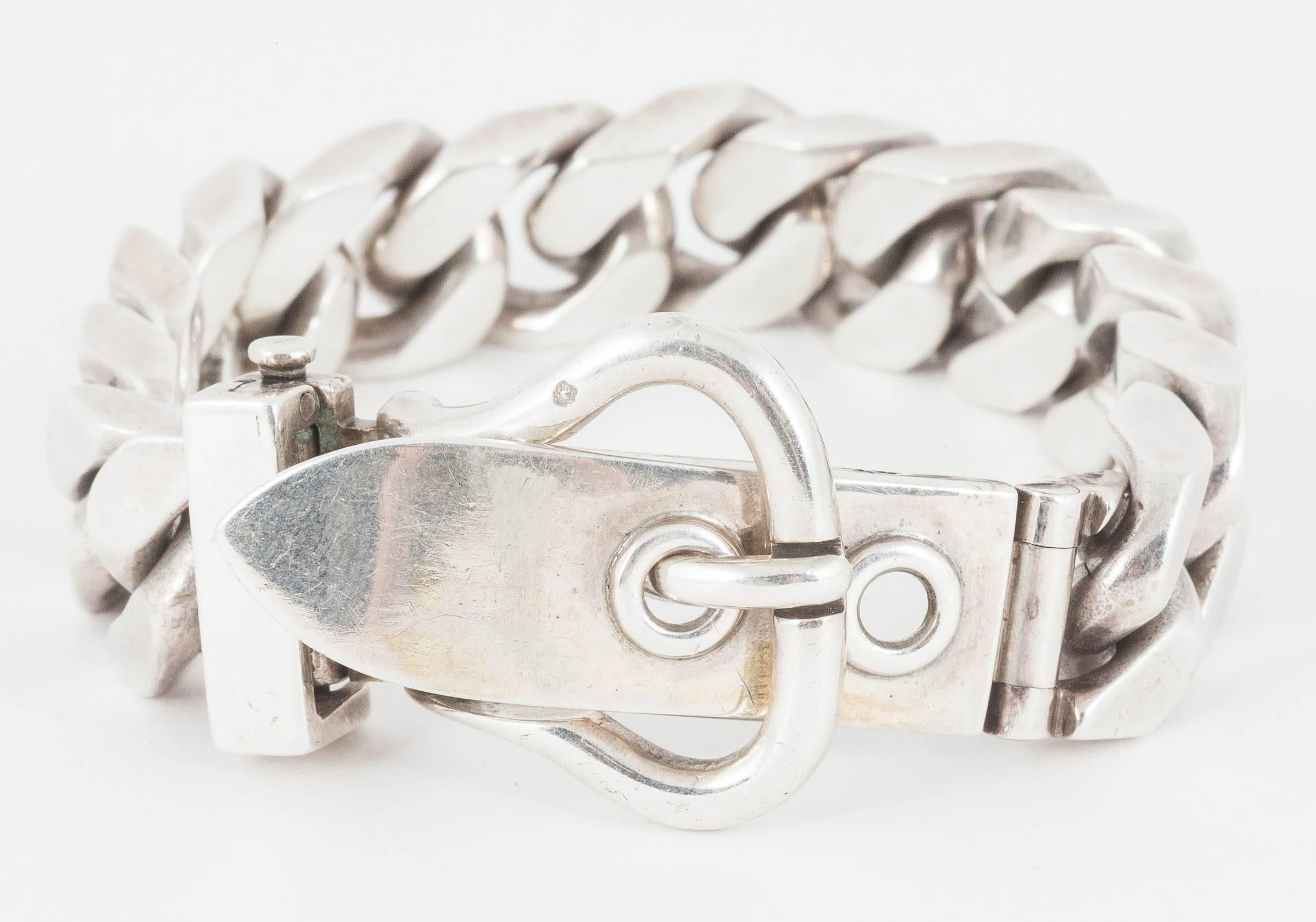 A heavy quality flat curb linked bracelet with a buckle clasp,signed Hermes of paris,weight 117 grammes,length 225mm,width of curb 15mm, c,1950-60 