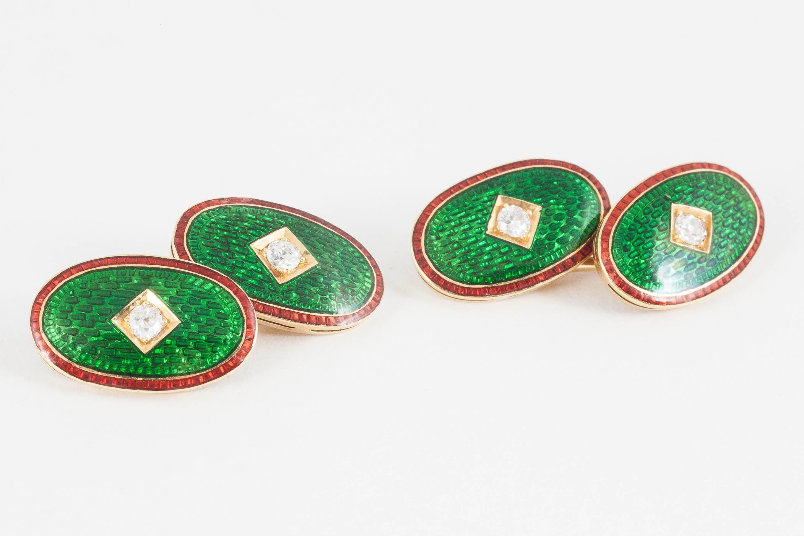 A finely made pair of oval,18ct yellow gold cufflinks, with a bright and vibrant green enamel face,edged in red enamel and set with an old cut brilliant diamond centre.English c,1890