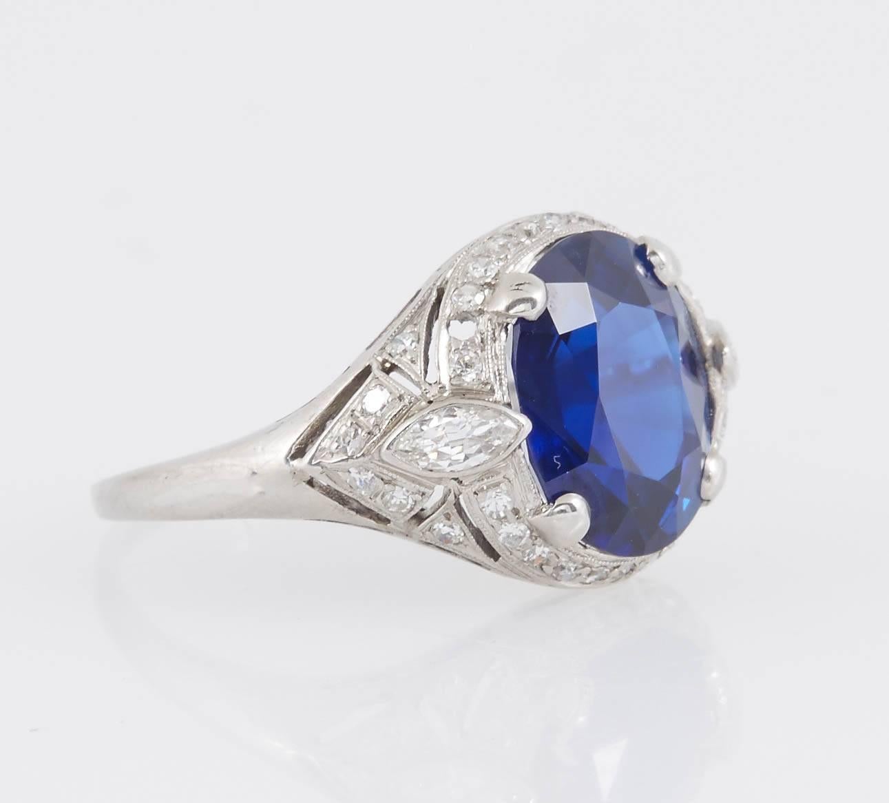 Art Deco ring finely crafted in platinum features a 5.19 Carat AGL certified Burma no heat Sapphire flanked by 2 marquise cut diamonds and accented with round cut diamonds all around. 

