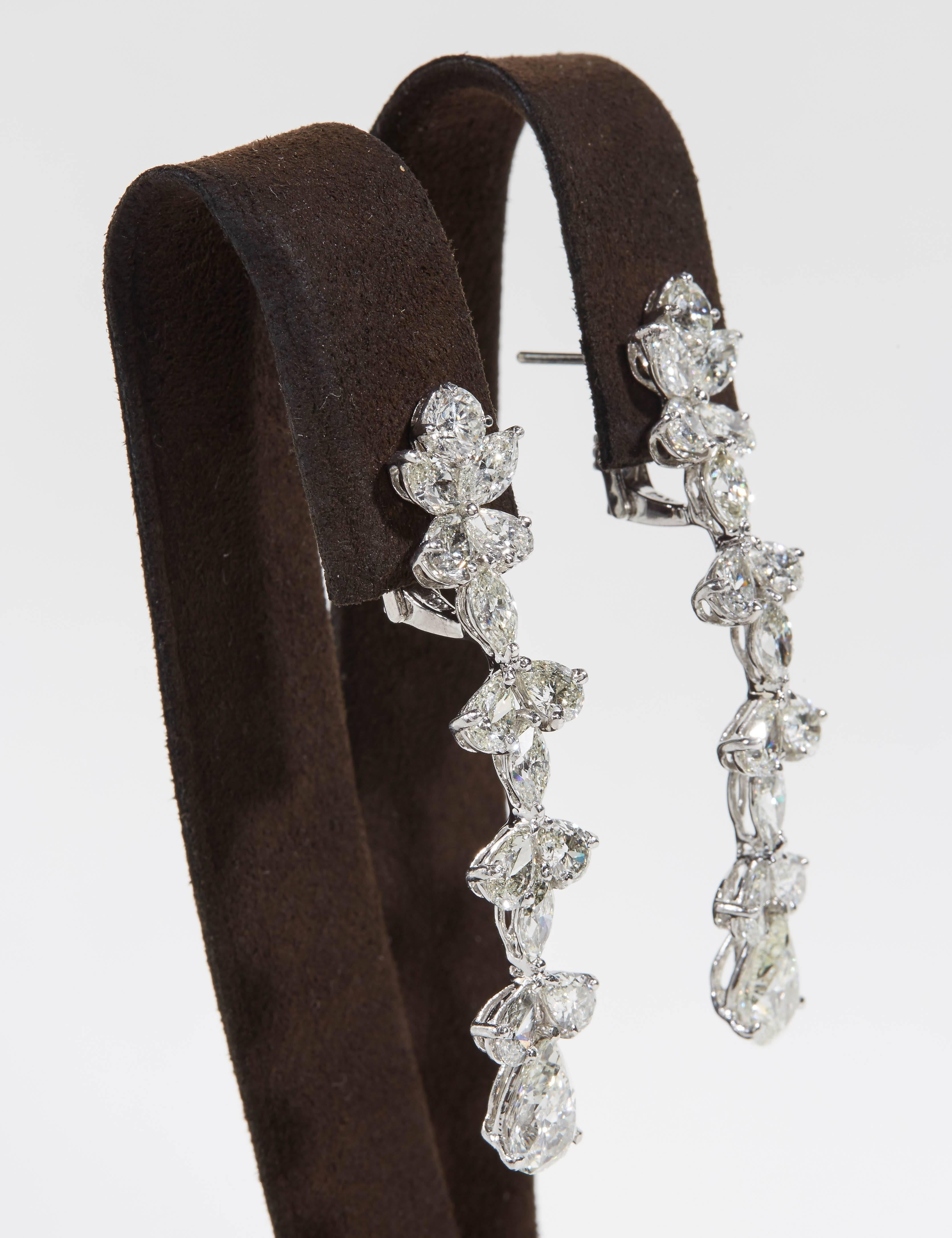 A beautiful pair of diamond dangle earrings,

1.50 carat Pear Shape drops suspended from 9.75 carats of Round, Pear and Marquise cut white diamonds.

Total diamond weight: 12.76 carats

Set in platinum

Just over 2 inches long. 

Designed to