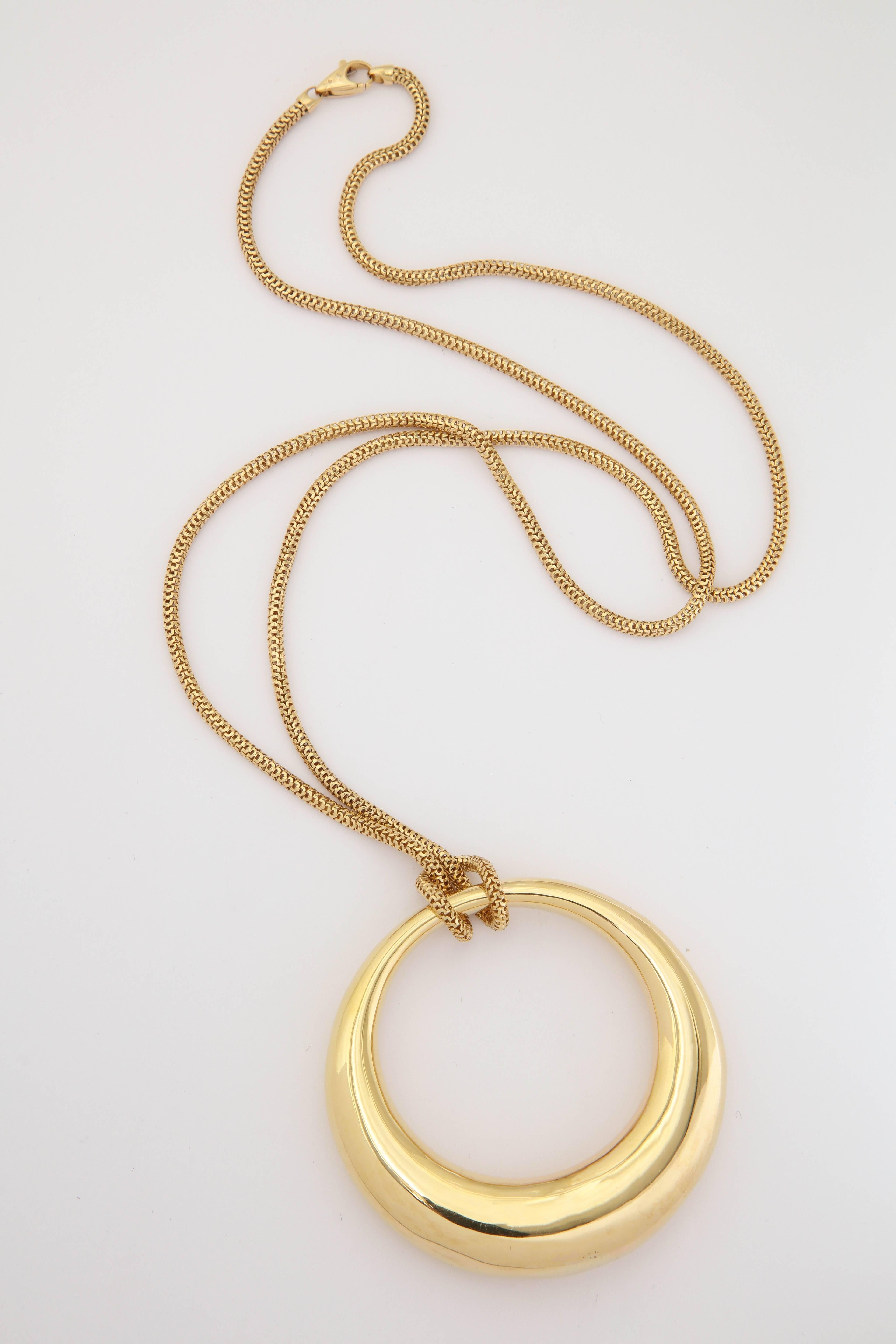 One 18kt Gold Oblong Moon Shaped Circular Three Dimensional Circle Loop Pendant Created In 18kt High Polish Gold Attached And Wrapped By An 18kt Gold Reptile Box Link Chain. Made In The 1980's In Italy.May Be Worn Doubled For A Choker Style look.