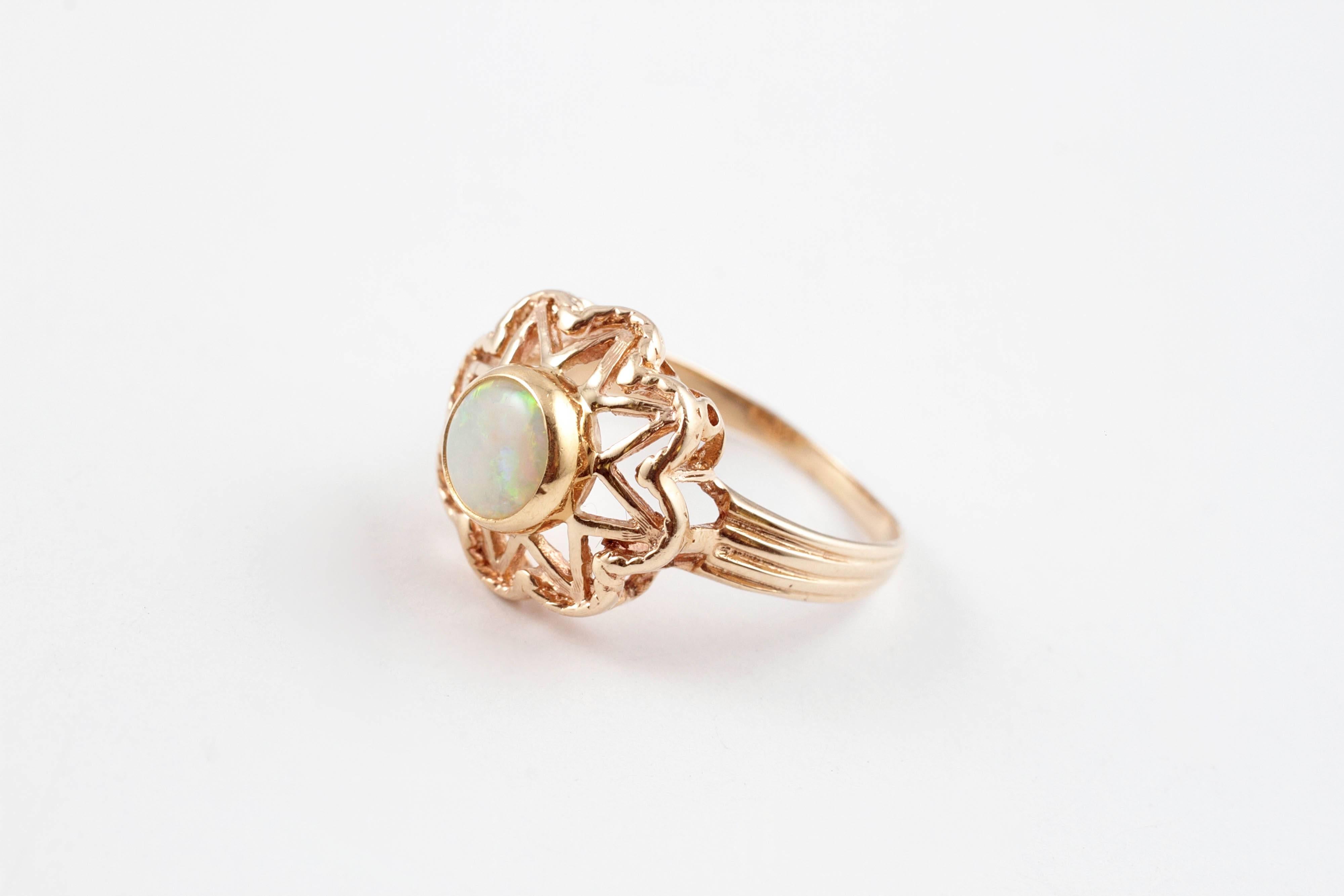 Round opal in star shaped mounting made of 14 Karat yellow gold.  Size 7 1/4.