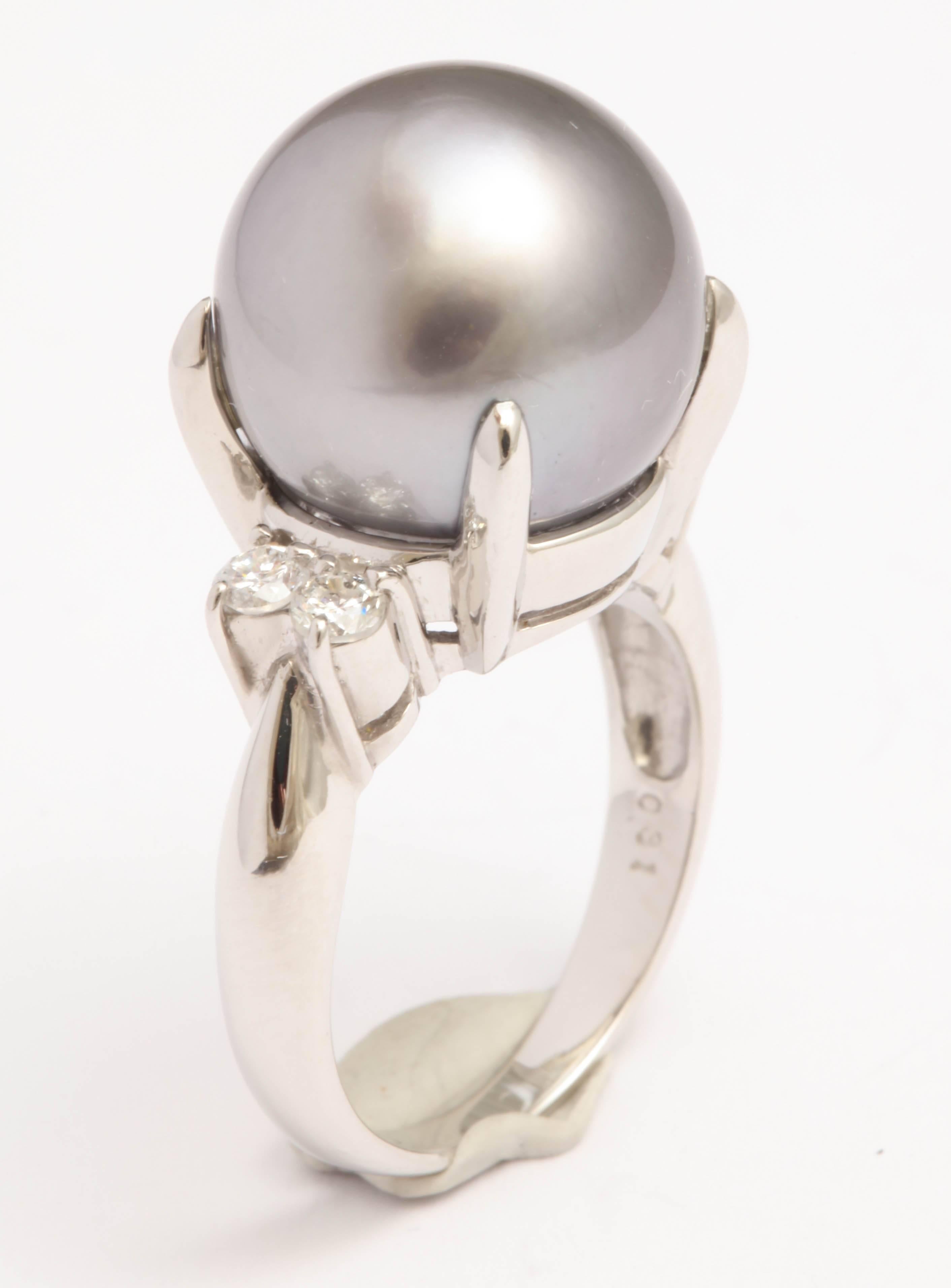 Platinum and 4 Diamond Ring  giving  an updated look to a traditional Pearl & Diamond Ring.
   Japanese made and centered on beautiful 13mm  Grey South Sea Pearl with 2 round full cut stones on either side - totaling 25pts - just enough to
