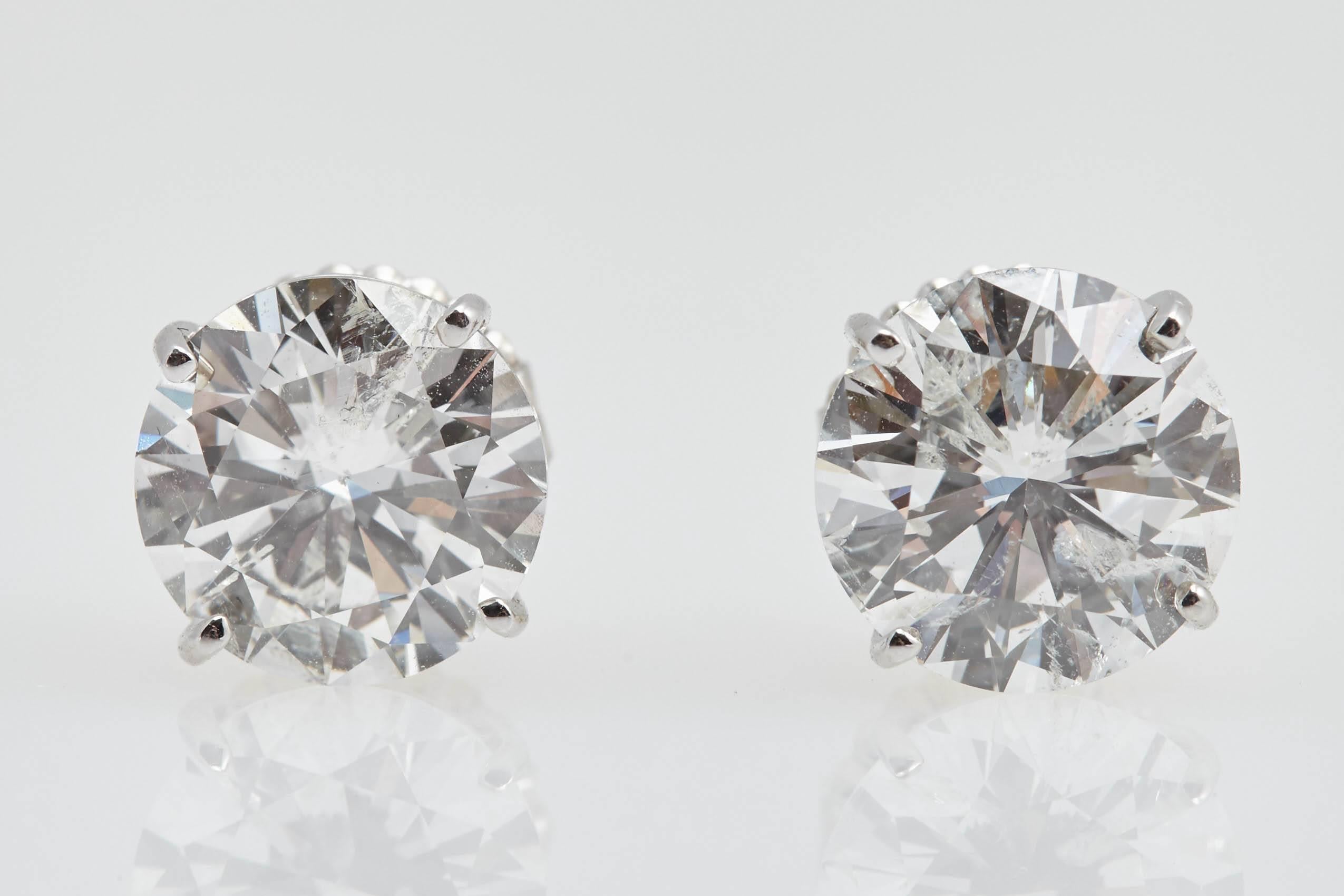  If you're looking for a pair of large diamond earrings that look great. These stunning earrings have a total weight of 7.01 carats. The diamonds are mounted in 14 karat white gold.  The diamonds are 