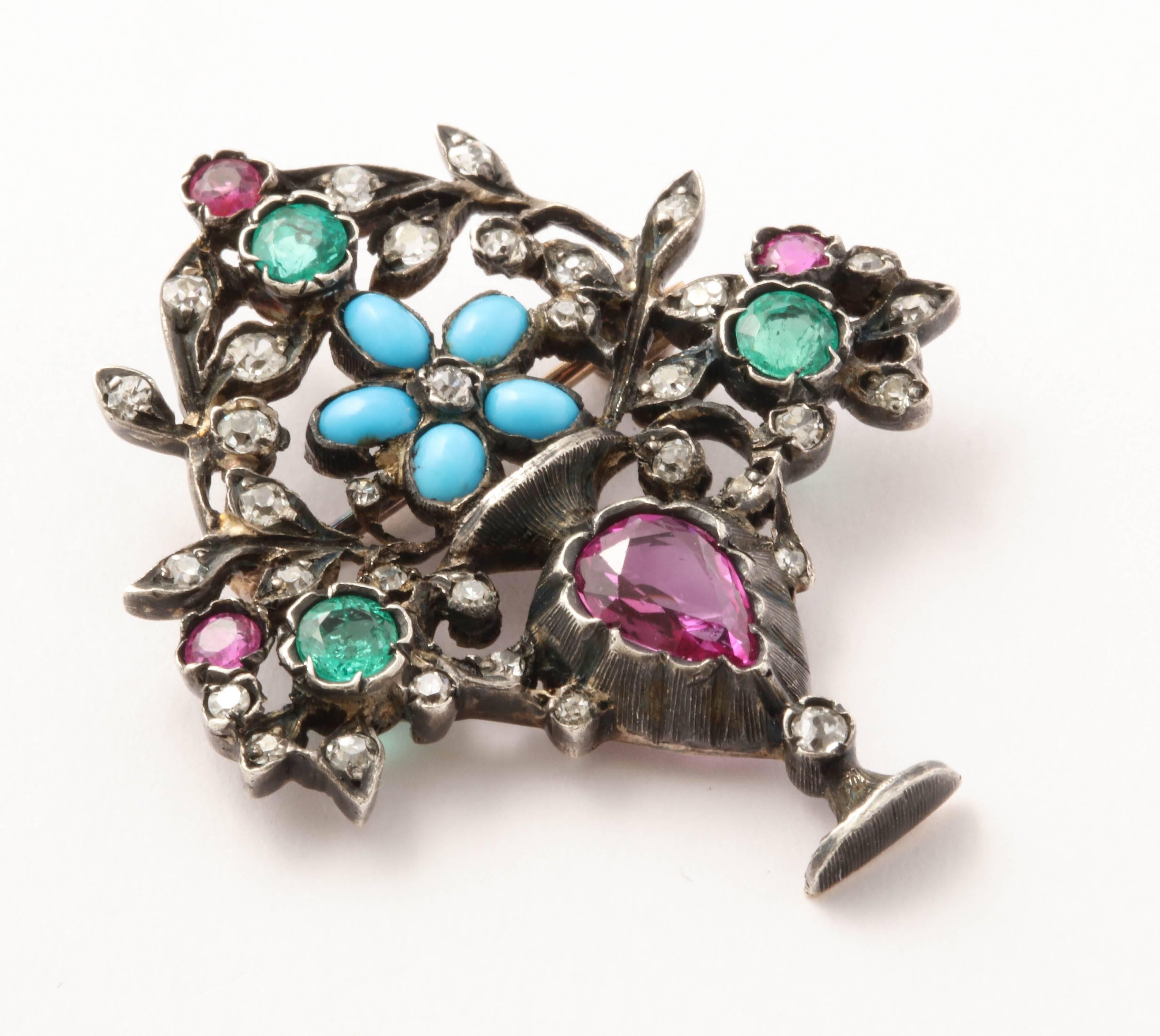 A superb flower-pot brooch in silver over gold, set with rubies, diamonds, emeralds and turquoises.  In pristine condition and with particularly vibrant colors.  