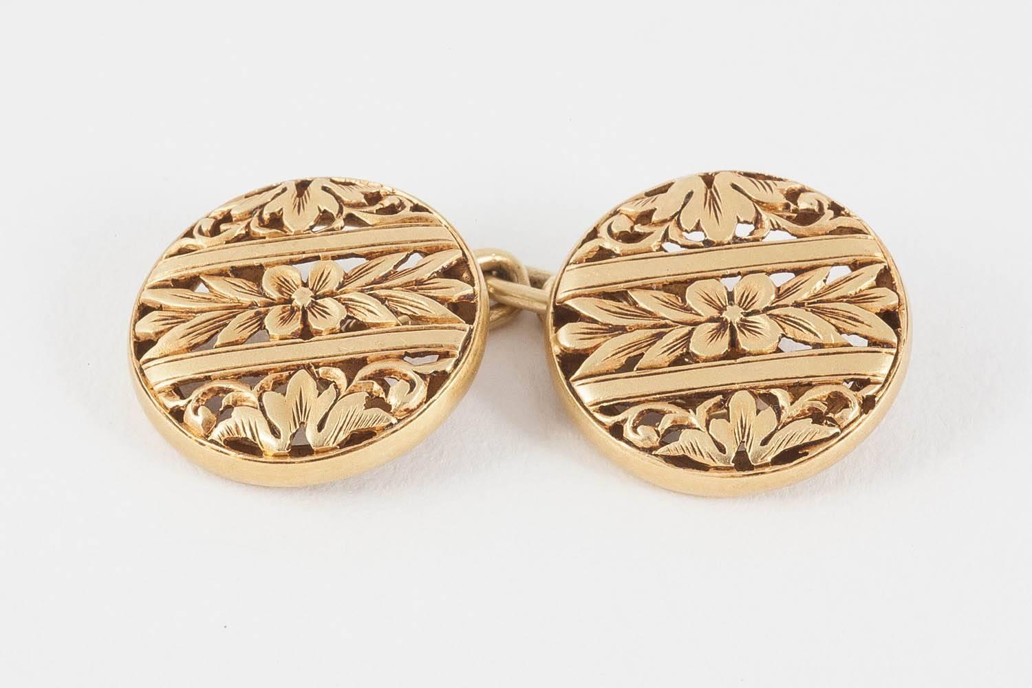 Antique cufflinks in 18 karat yellow gold. Double sided of openwork floral design with chain connections. The gold has a particular soft patina. In the Art Nouveau style. French marks.
Measures 12mm across.
Antique (over 100 years old).
Late 19th