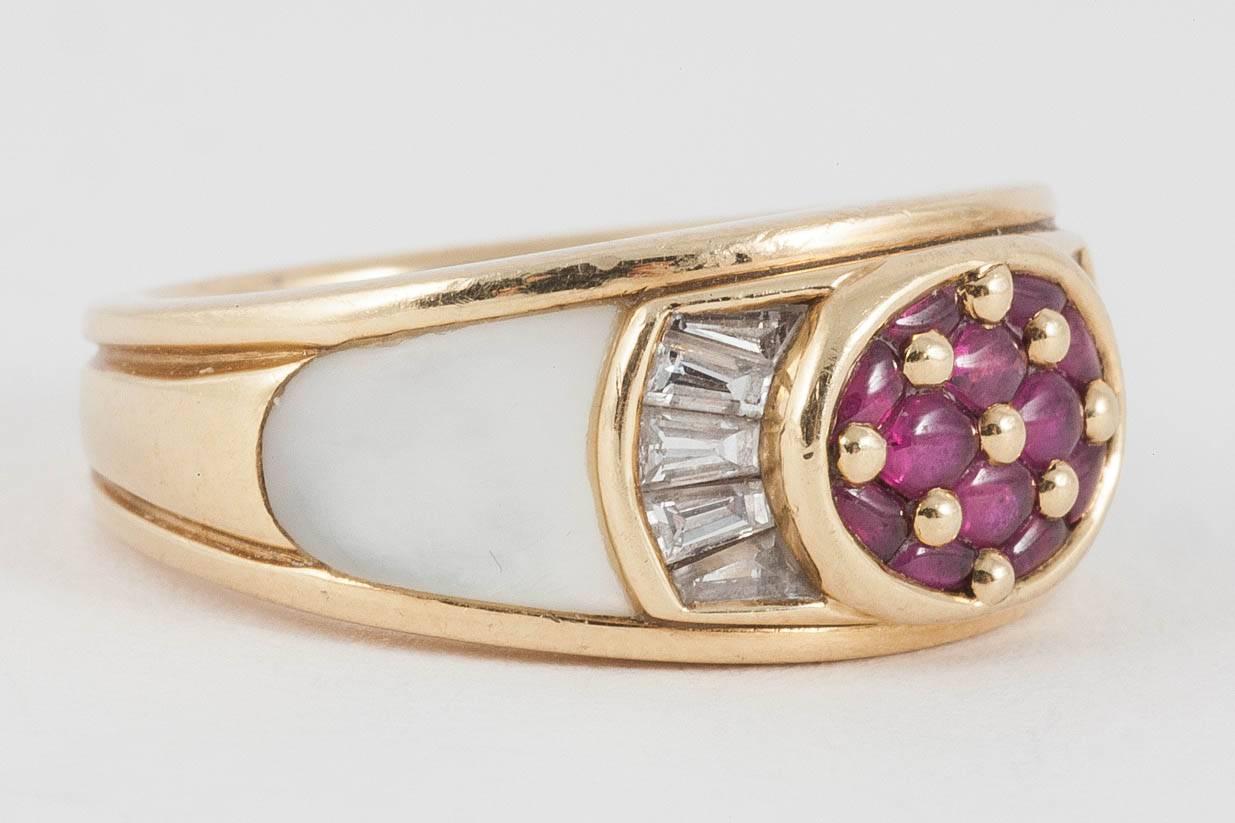 A heavy quality and finely made ring set with buff topped Burma rubies, the shoulders with graduating baguette cut diamonds, and below, set with mother of pearl in 18kt gold. Signed by Mauboussin of Paris c 1990