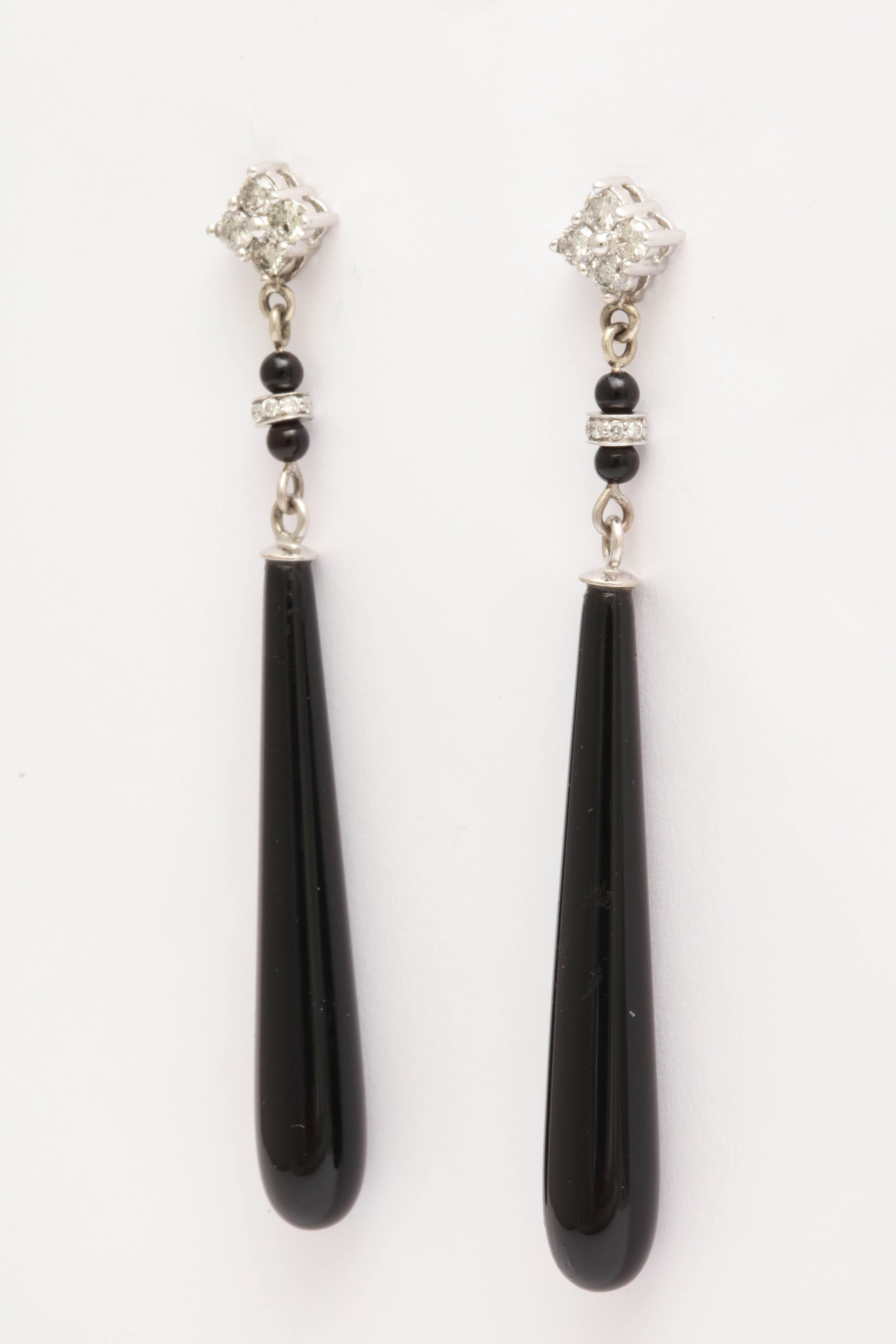 Elegant black onyx and diamond long drop earrings. The post top has 4 round brilliant cut white diamonds with 2 mm. black onyx beads with a diamond and gold rondelle in between.