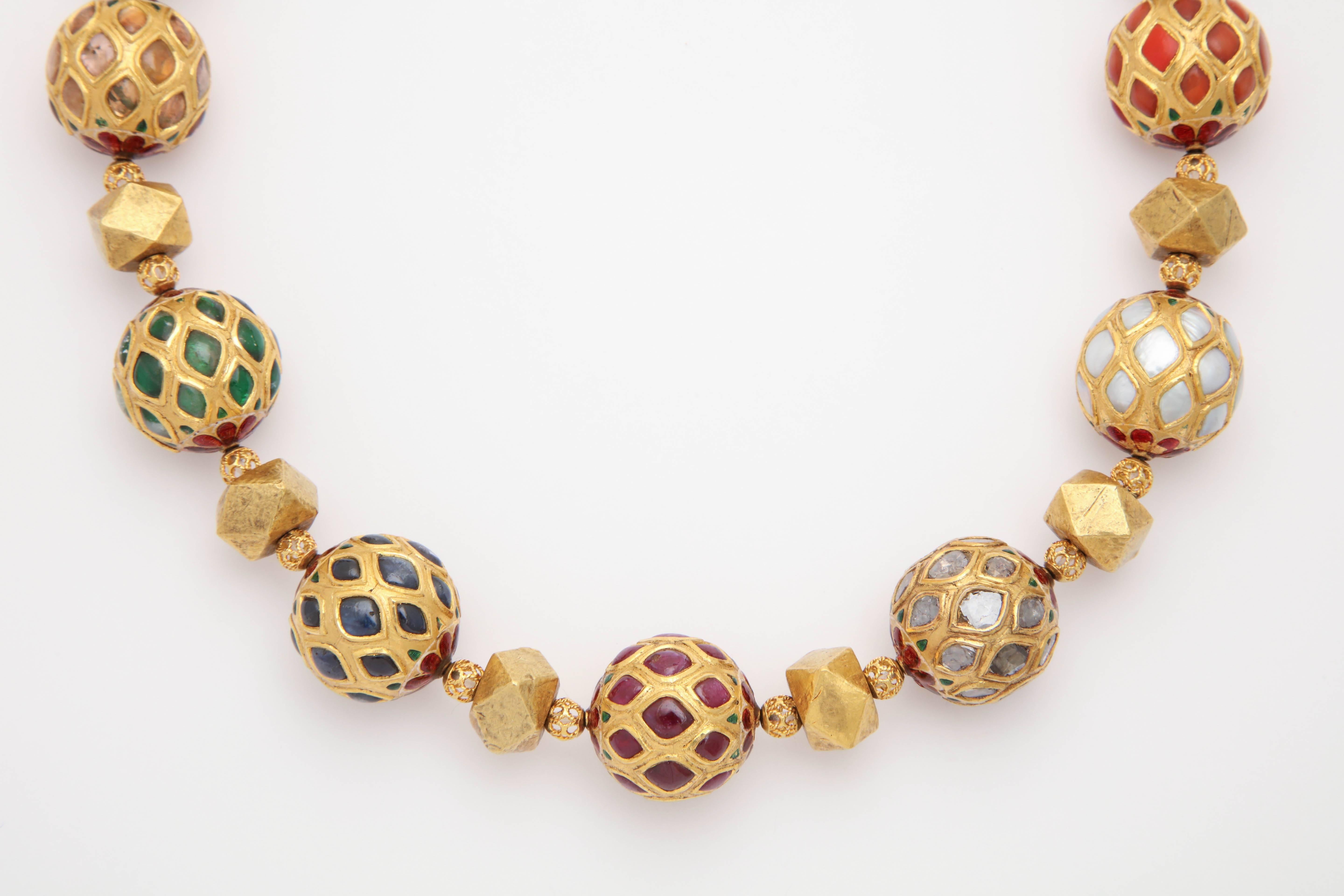 A Contemporary Navratna Kundan Necklace. The necklace is composed of 18 and 22kt yellow gold beads, 9 are multi gem set Kundan beads. The stones used are: , Hyacinth (natural zircon), Coral, Pearl, Diamond,Ruby, Sapphire, Emerald, Topaz and Cat's