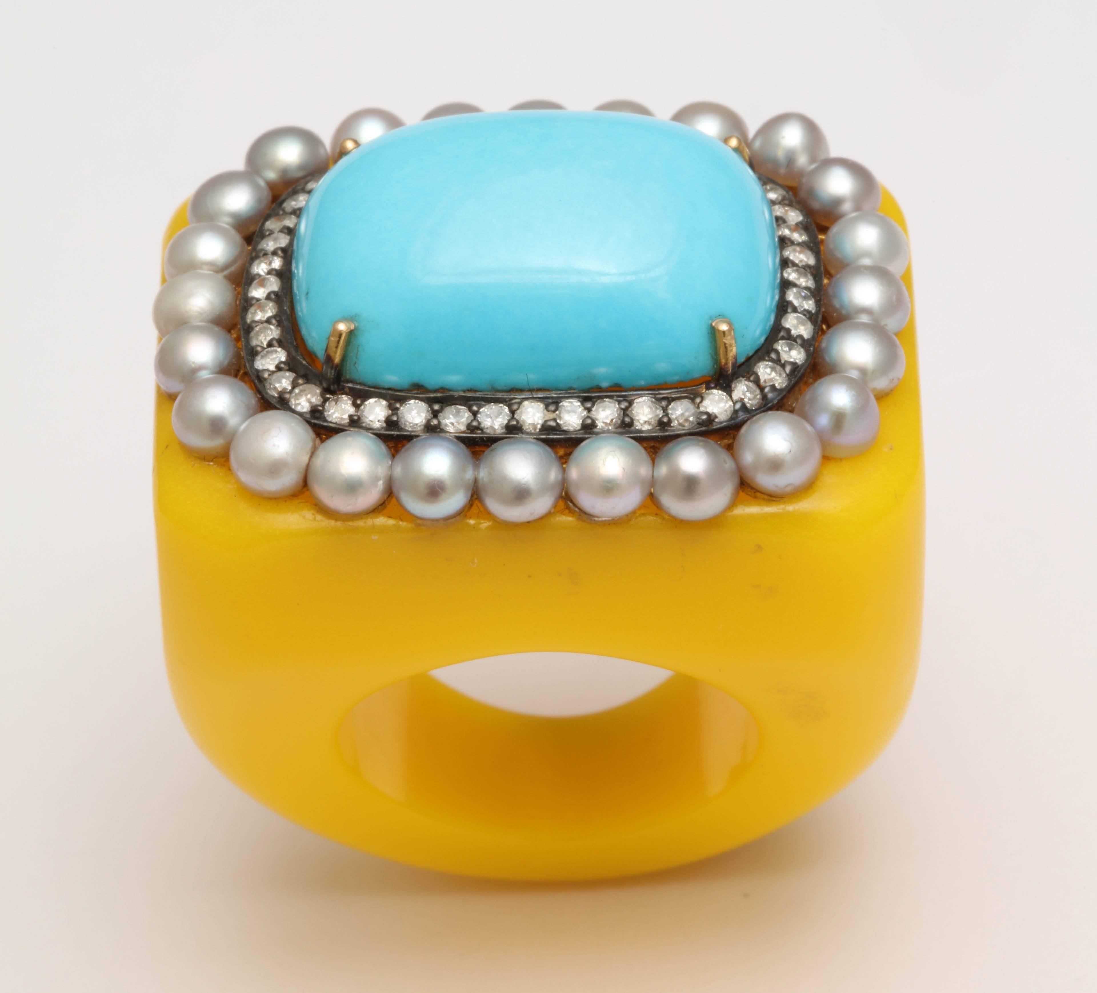 A yellow Plastic ring set with a cushion shaped reconstituted turquoise, surrounded by a single row of diamonds and a border of pearls. There are approximately .45 ct of diamonds.
Size 6.75