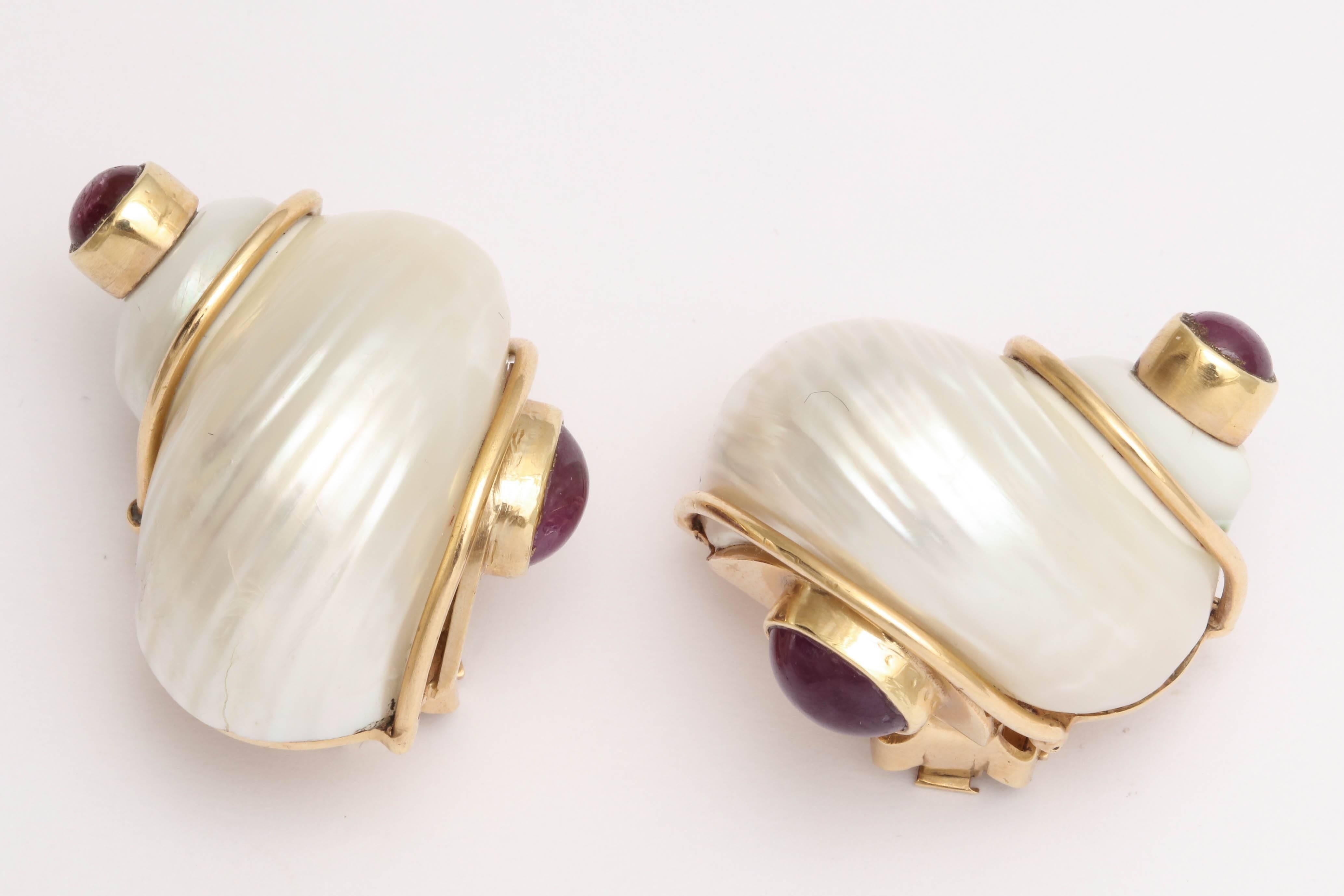 One Pair Of Ladies Large Size Turbo Shell Earclips Designed By Seaman Schepps Created In 14kt Yellow Gold And Made In The 1940's. Further Flanked With Four 10mm Cabochon Rubies On Both Sides Weighing Approximately 2 Carats Total Weight.NOTE: Clip On