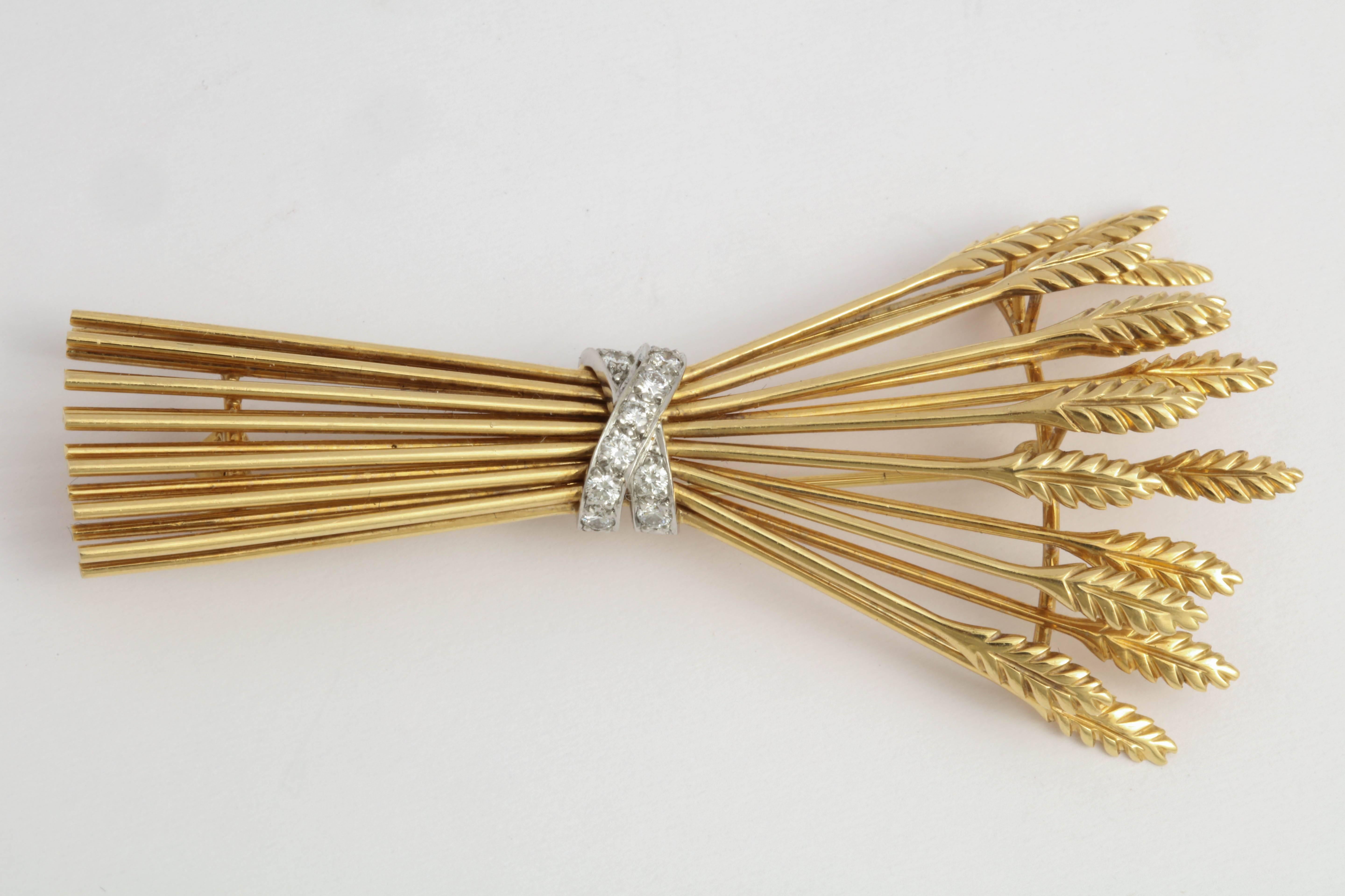 Charming 18kt Yellow Gold stack of 15 Sheaves bundled by a criss cross band set with 11 full cut Diamonds.  Very distinctive.  Marked 750 on the reverse of one sheaf and Tiffany & Co on another. Diamond weight: approx.35pts.

Lightweight and very