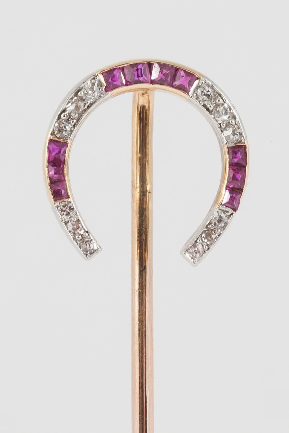 A platinum set and gold mounted Tiepin in the form of a horseshoe,the diamonds brilliant cut,and the attractive Burma rubies square cut and channel set.French marked c,1900