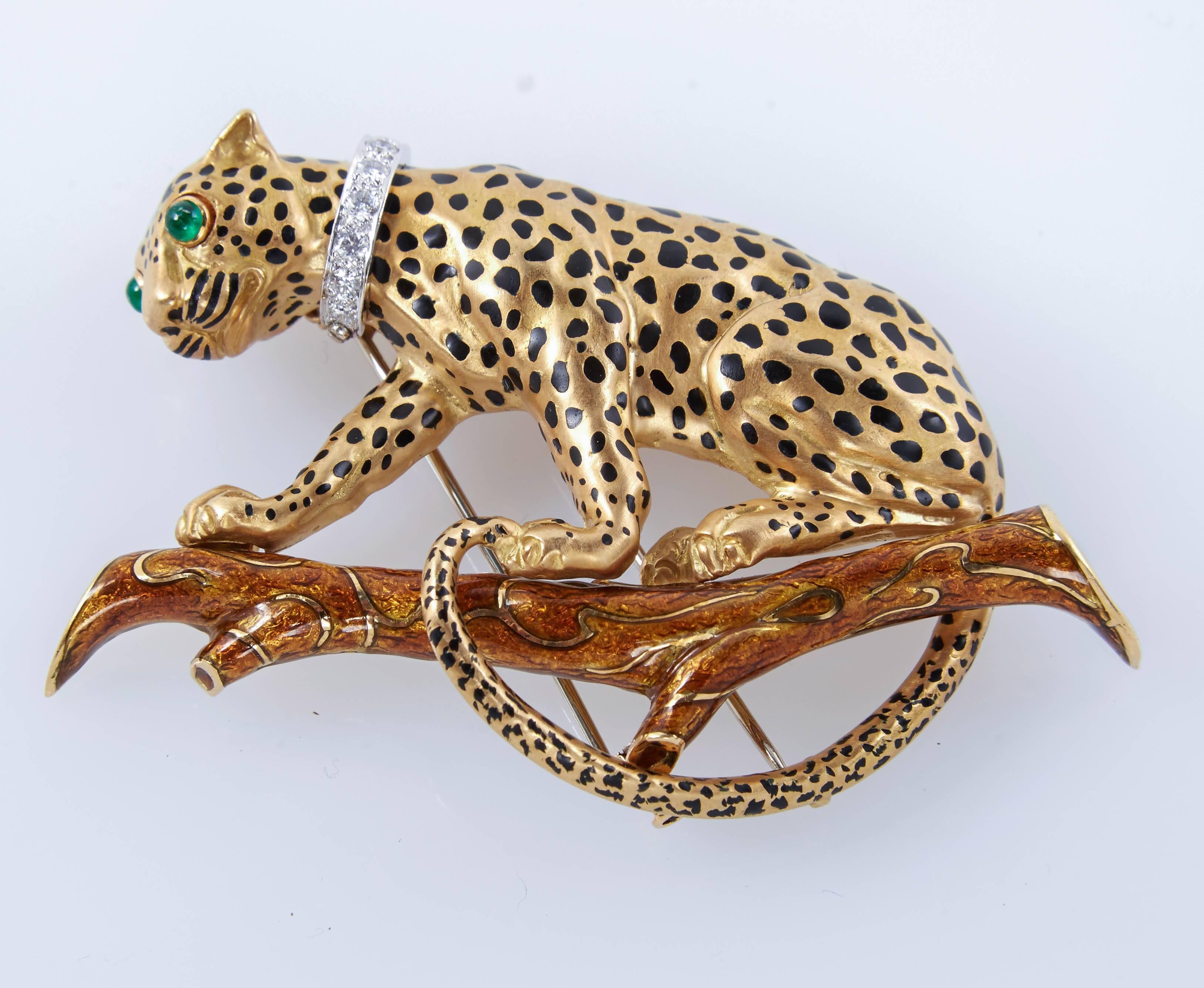 This beautiful leopard brooch is an iconic example of David's Webb nature-inspired designs. Brooch is crafted of 18k yellow gold with black enamel spots. The feline is perched atop a branch of brown enamel. Two cabochon emeralds form its eyes, while