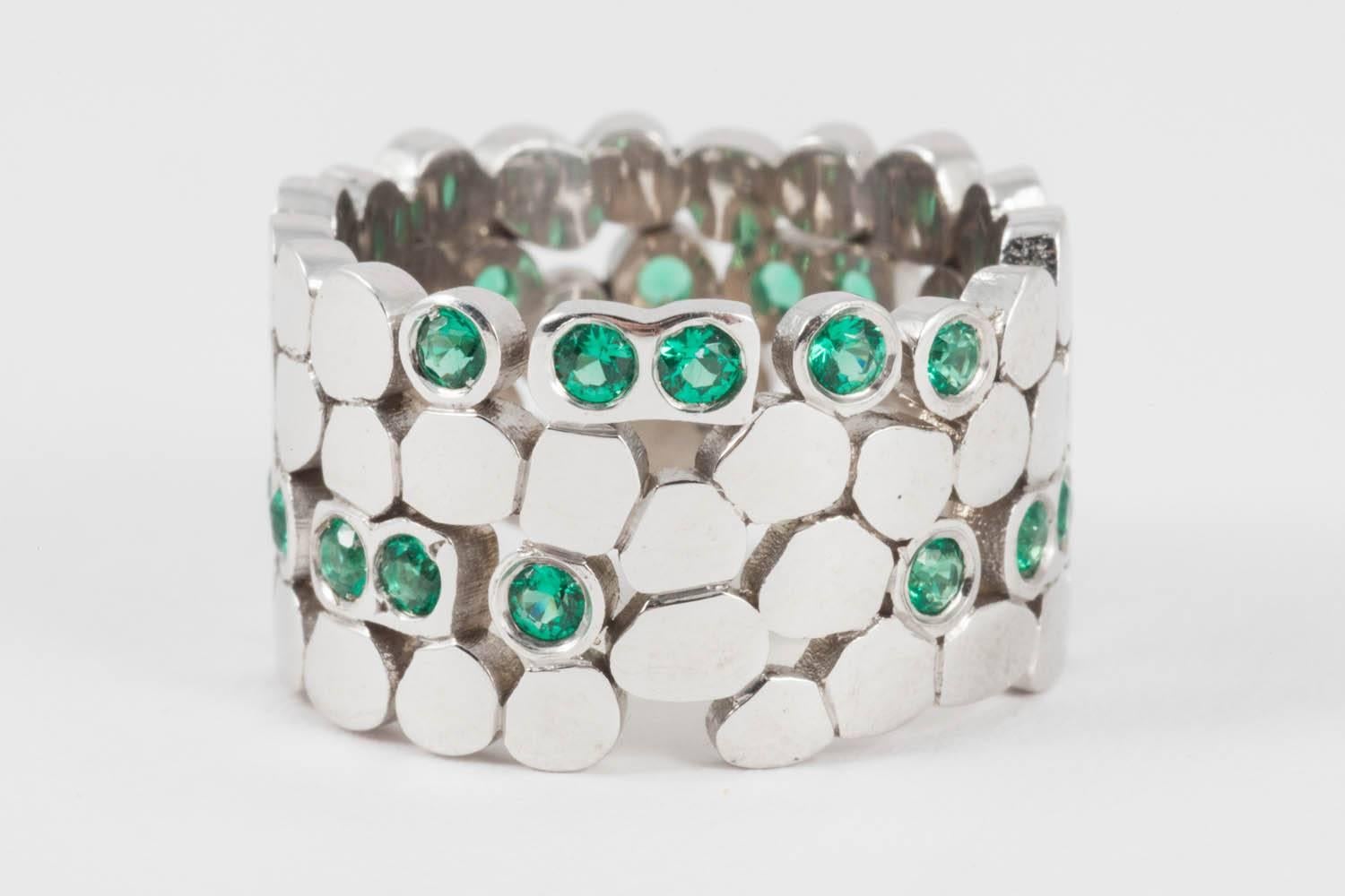 Code by Edge uses morse or binary code to hide hidden messages within the beautiful jewellery. This example is of a band ring and set with emeralds using the morse code to spell out the name "Claire". Set within the ring in emeralds are