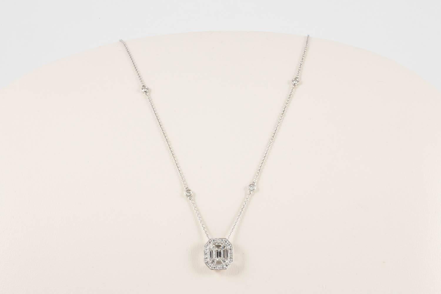 A very pretty, Art Deco inspired diamond pendant set to a fine diamond set chain. The use of baguette and round cut diamonds give the impression of an important single stone necklace with the halo border though clever mounting makes this have all