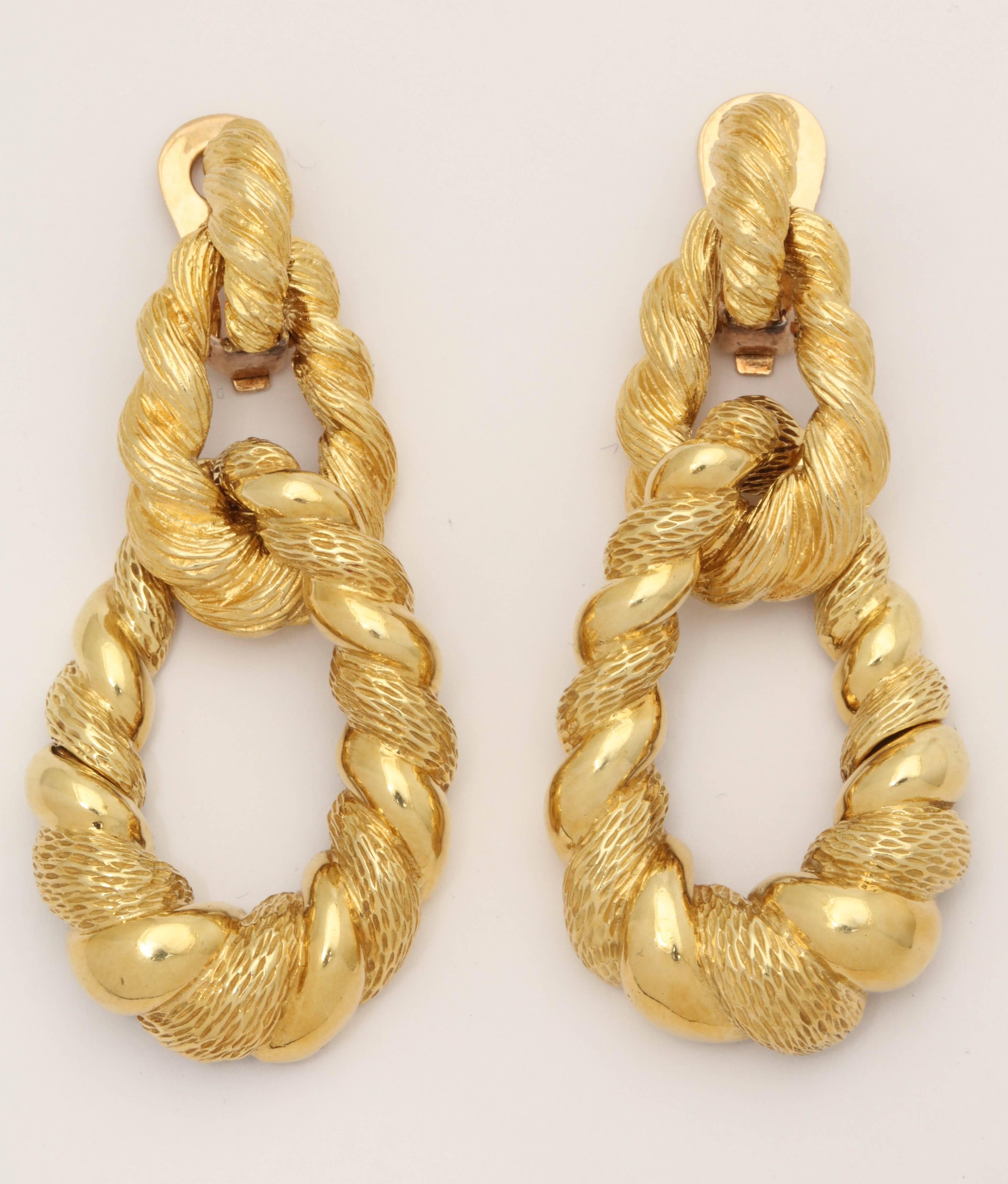 One Pair Of 18kt Yellow Gold Lond doorknocker Loop Earrings With 14kt Gold Clip Backs For Extra Strength And security. Earrings Are Designed With an Alternating Gold Nugget Finish And With A High Polish Gold Effect To Give A More Textured Gold Look.