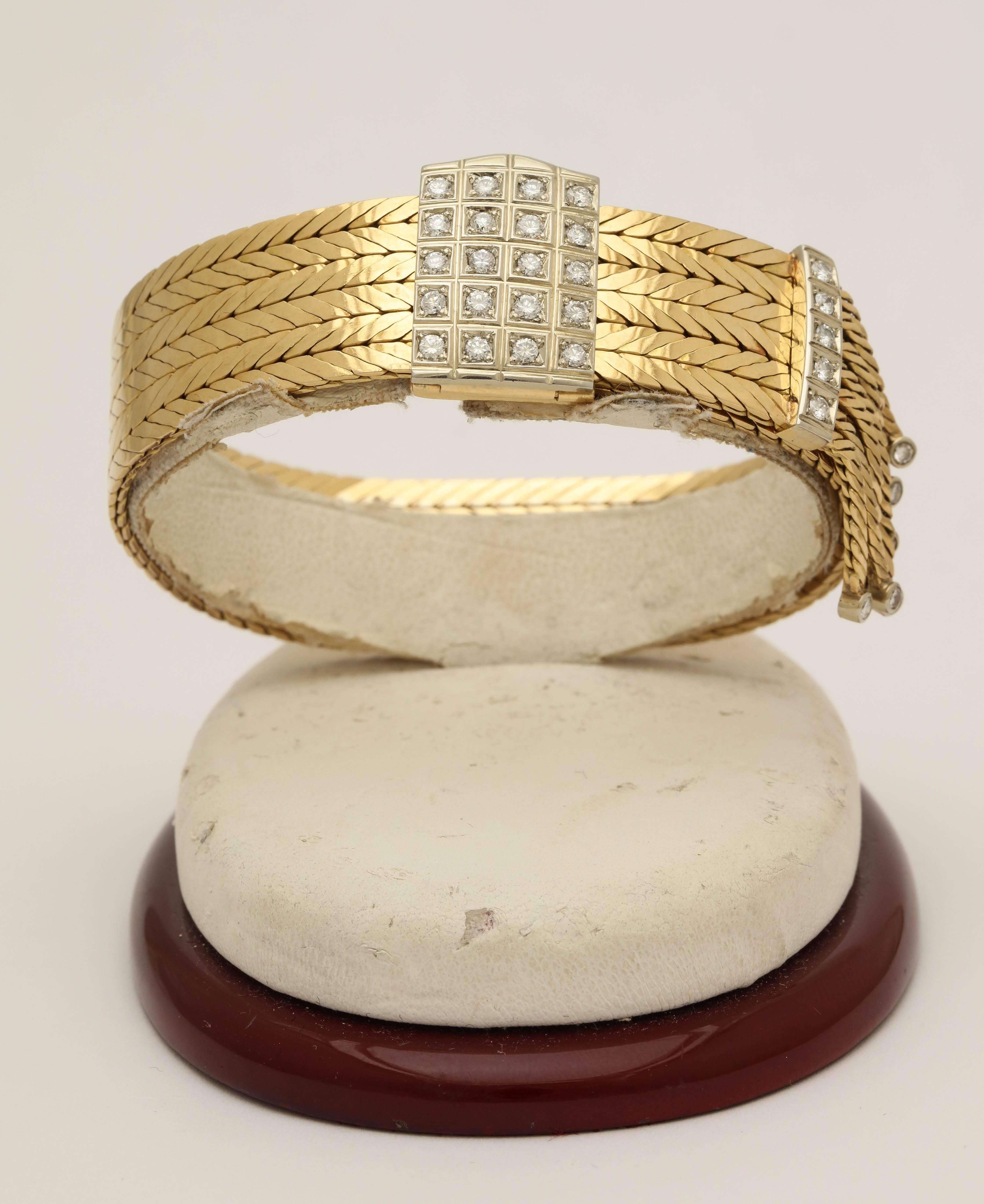 One Elegant Ladies 18kt Yellow Gold Herringbone Textured Belt Strap Bracelet Embellished With Twenty High Quality Full Cut Diamonds On The Clasp Weighing approximately 1 Carat Total weight. Further Designed With 12 Diamonds On The Fringe And Tassel