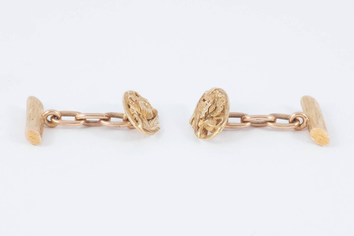 Antique cufflinks in 18 karat yellow gold openwork with a carved floral, leaf and bud design. Single sided with a carved branch terminal and chain link connection. In fine condition, of perfect weight and exceptional patina. French marks and from