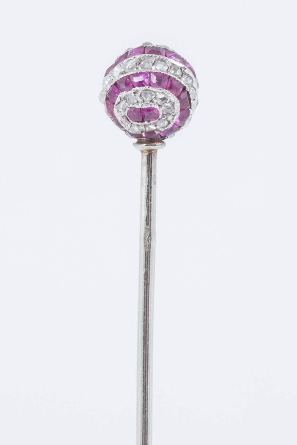 A platinum mounted tiepin in the form of a ball,set with rose cut diamonds,and calibre set,burma rubies of fine colour.French marks,probably made by Cartier or Lacloche,but not signed C,1900