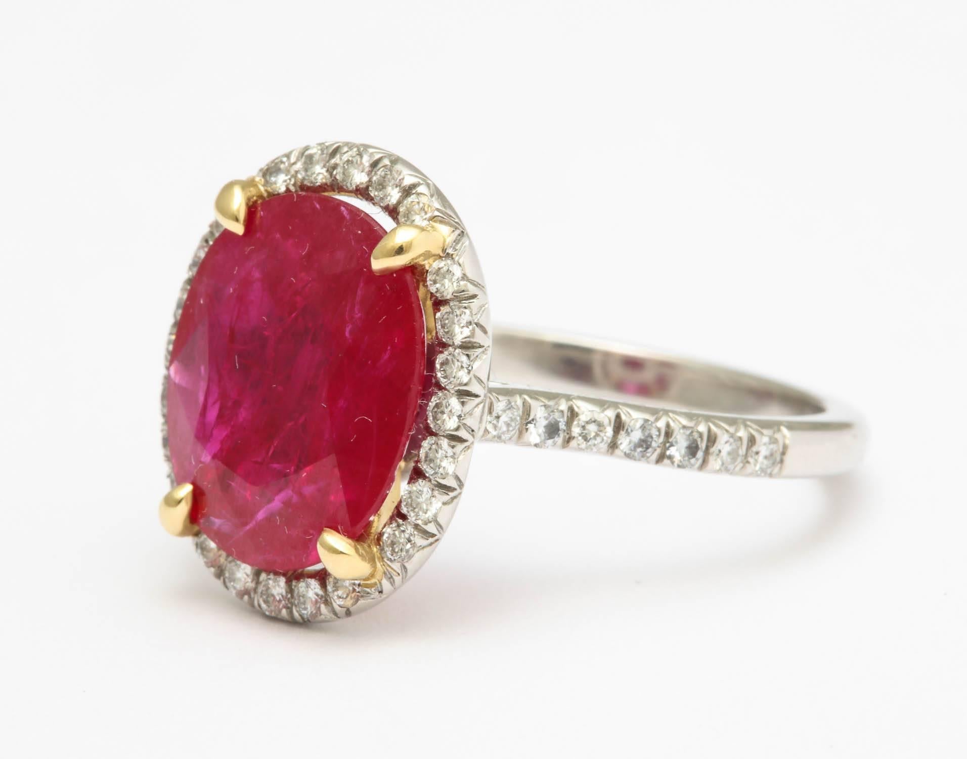 platinum wire setting centering an oval ruby 4.56
surrounded by 30 full cut diamonds 0.30 carats and flanked by 14 full cut diamonds 0.15 carats
