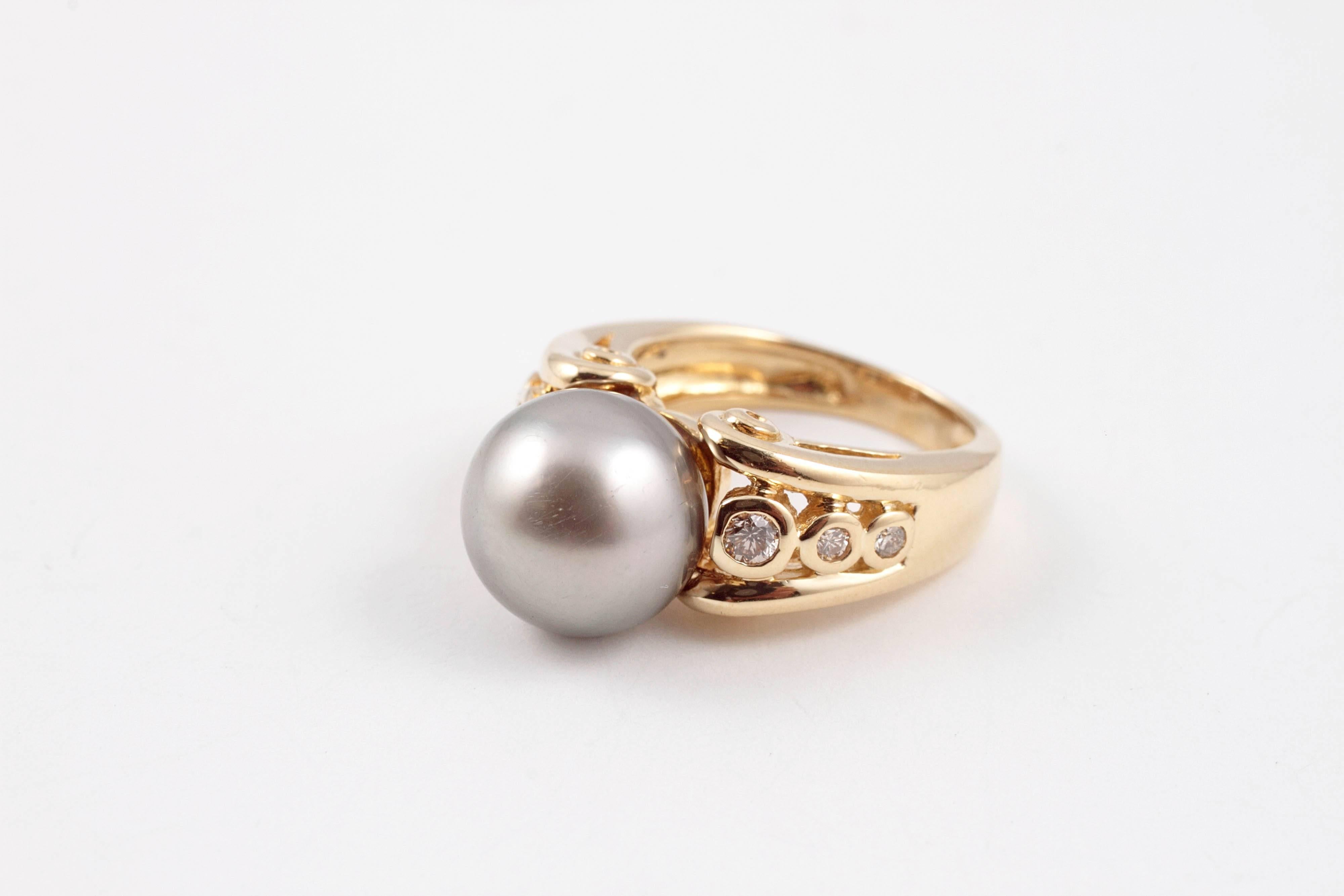 Fabulous ring!  In 18 karat yellow gold, this 11.00 mm natural color Tahitian cultured pearl is flanked by diamonds and looks incredible on the hand!  In size 5 3/4.
