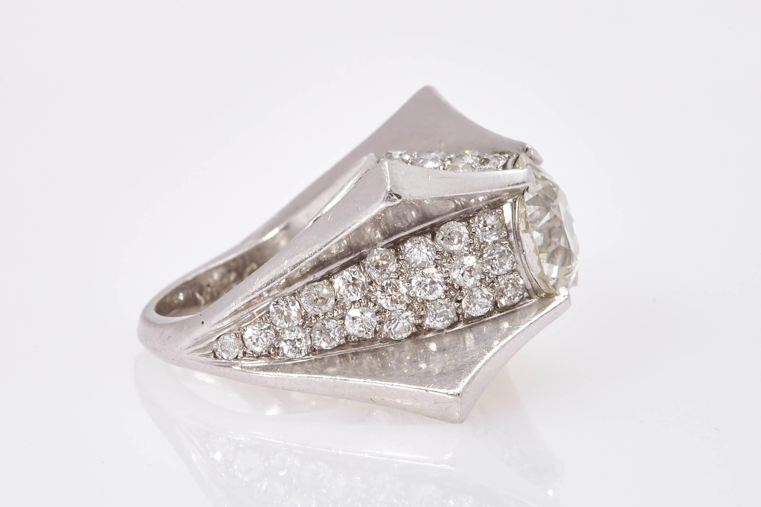 A sophisticated cocktail ring in 18kt white gold, in an unusual shape resembling a spatial object, the mounting embellished with diamonds, showcasing an 3.80cts J colour VS2 clarity old mine cut stone. Made in Italy, Circa 1950s.