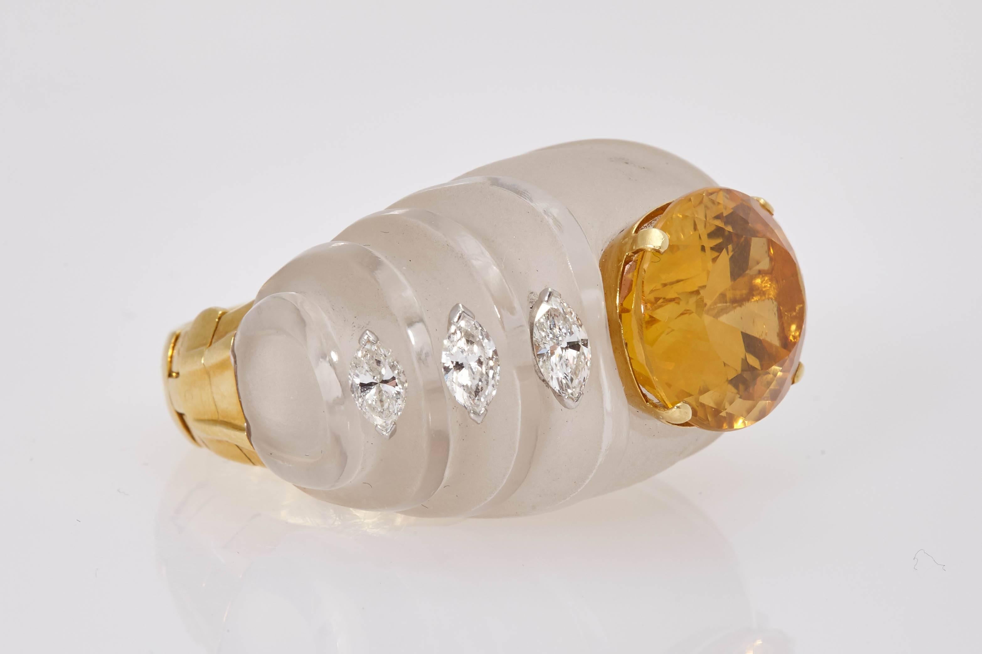 A large and impressive cocktail ring, the body made out of carved rock crystal, showcasing an oval citrine, highlighted by marquise cut diamonds, mounted on 18kt yellow gold. Made in the USA, circa 1970s. 