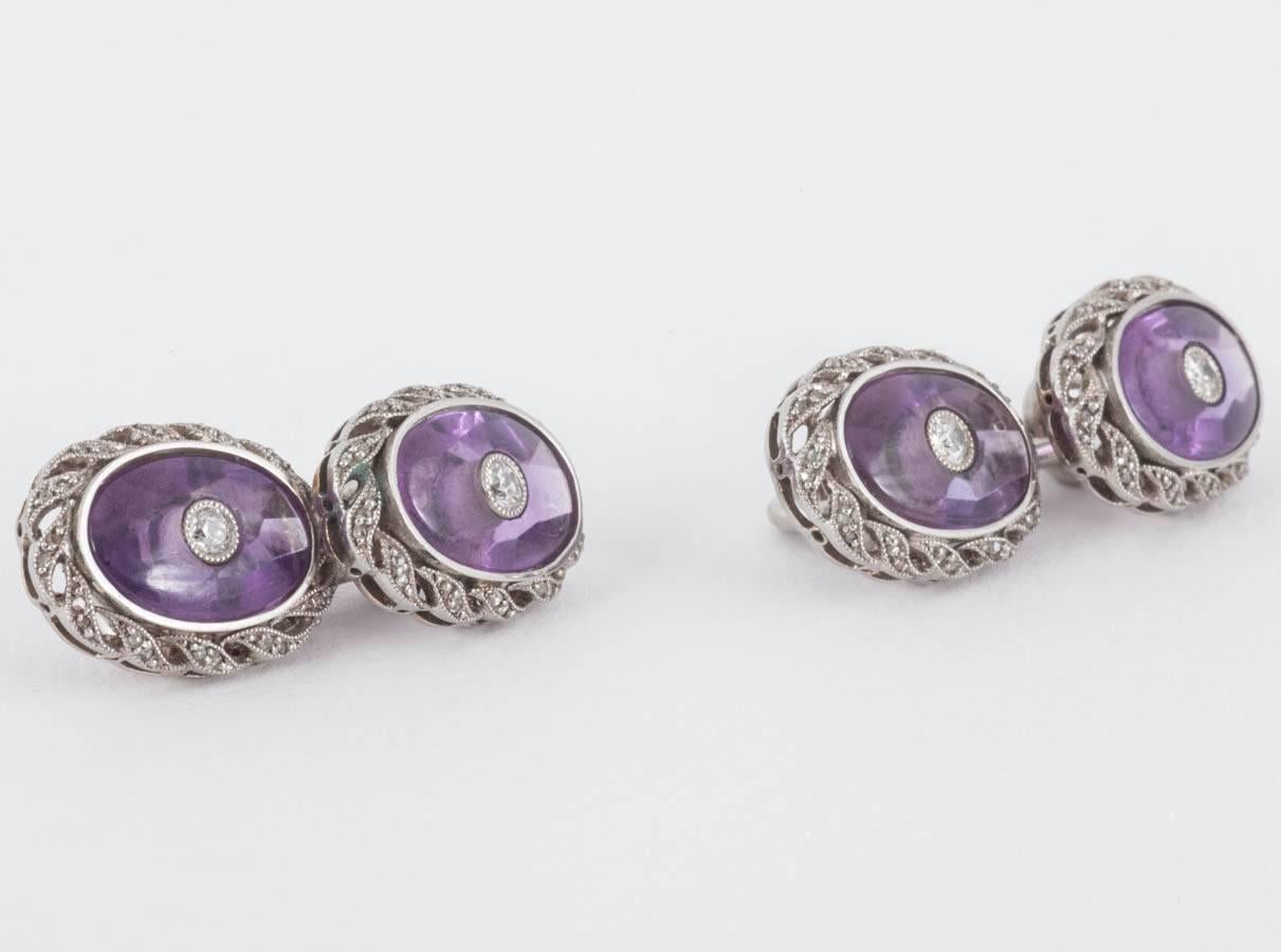 A fine pair of antique cufflinks with brilliant cut diamonds and amethysts. Double sided with a surround of rose cut diamonds set in an unusual scroll design border and mounted in 18 karat white gold. Stamped Bravete (French import mark).
Measures