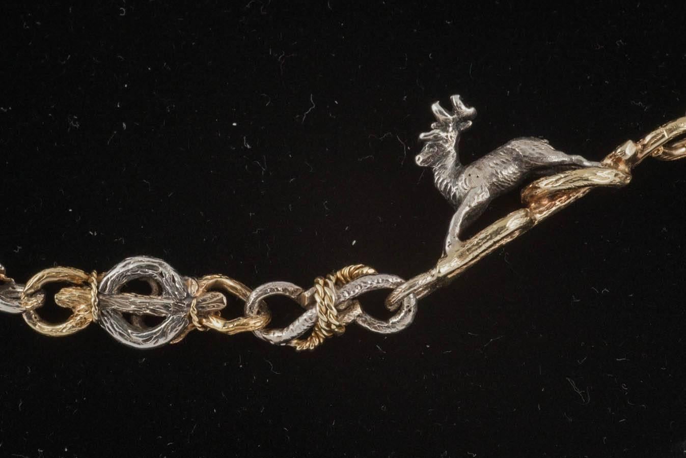 A rare,silver and gold necklace of carved branch motifs with foxes,hounds and stags,the animals in silver,the connections in silver and gold.English c,1870