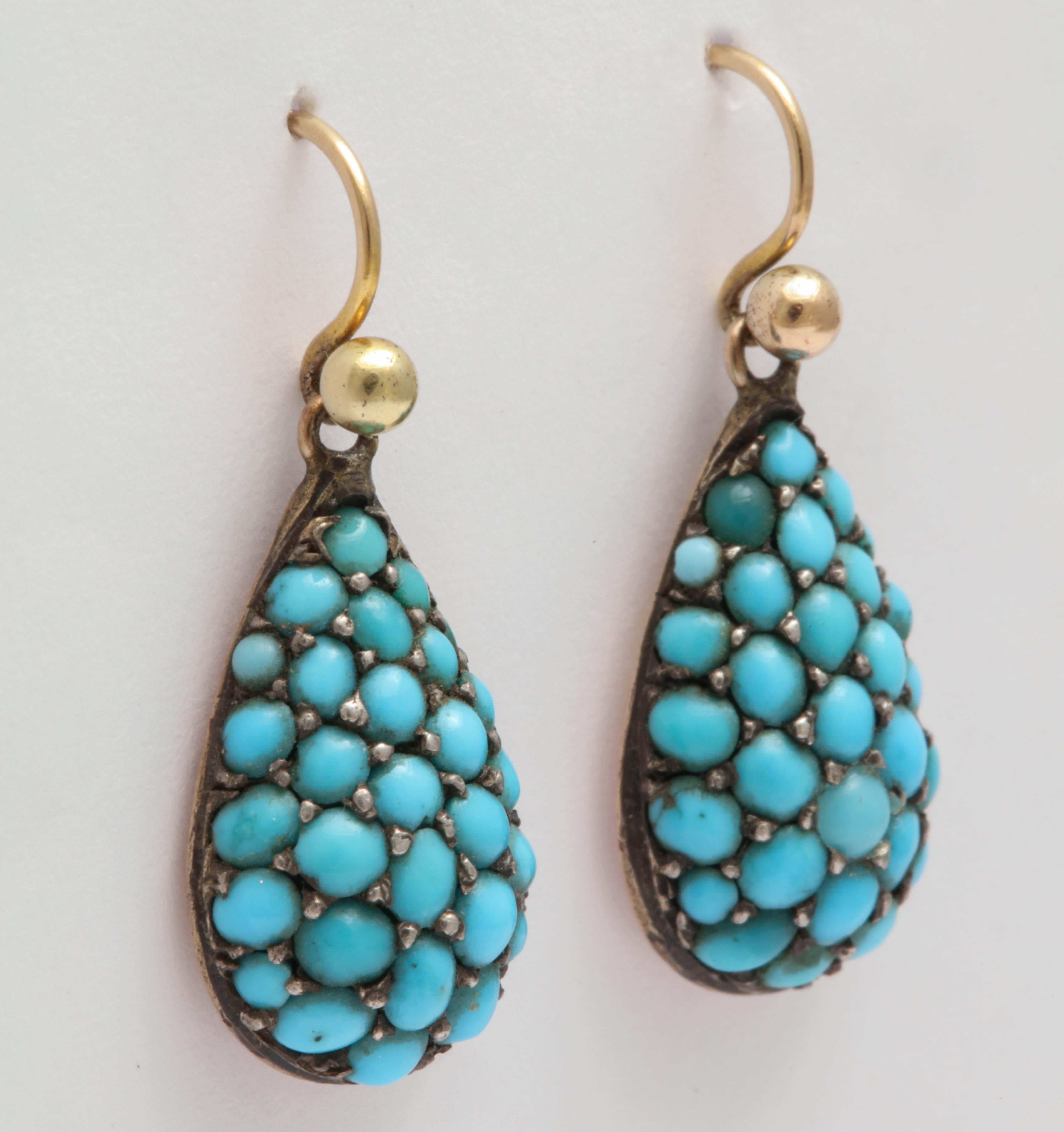 Beautiful quality and design. These teardrop shaped earrings are set with Persian turquoise in a rounded design on the front with a flat back of 9K yellow gold. Made in England. 