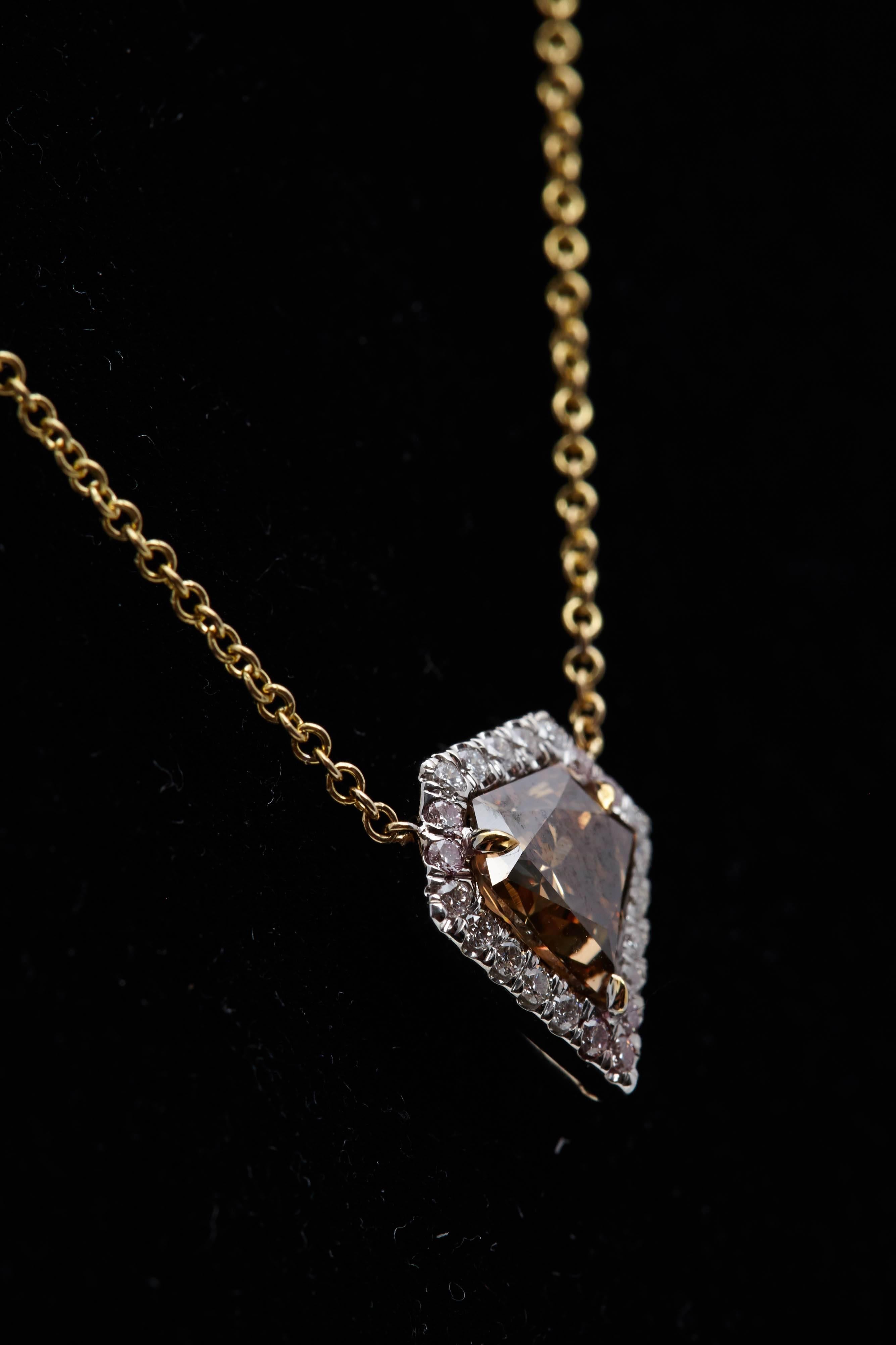 Shield shaped diamond weighing 1.45 carats surrounded by 22 round diamonds weighing .27 carat. The shield shaped diamond has a certificate from the Gemological Institute of America stating that it is Natural Fancy Orange-Brown in color and VS2 in