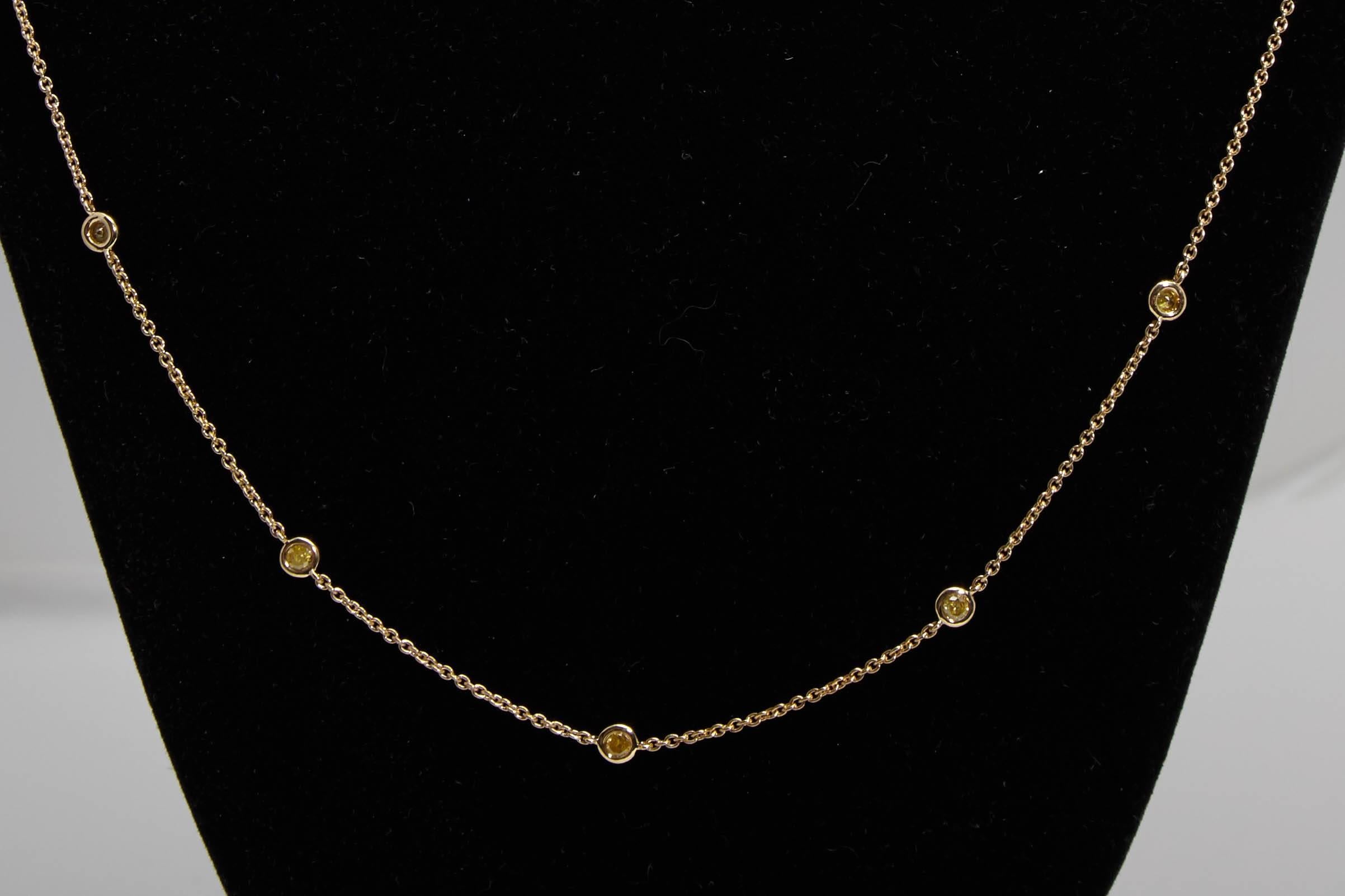 Diamond by the yard style 30 inch 18 karat yellow gold necklace. The diamonds weigh approximately 1.40 carats and are yellow in color. The diamonds are bezel set and are equally interspersed along the length of the chain.