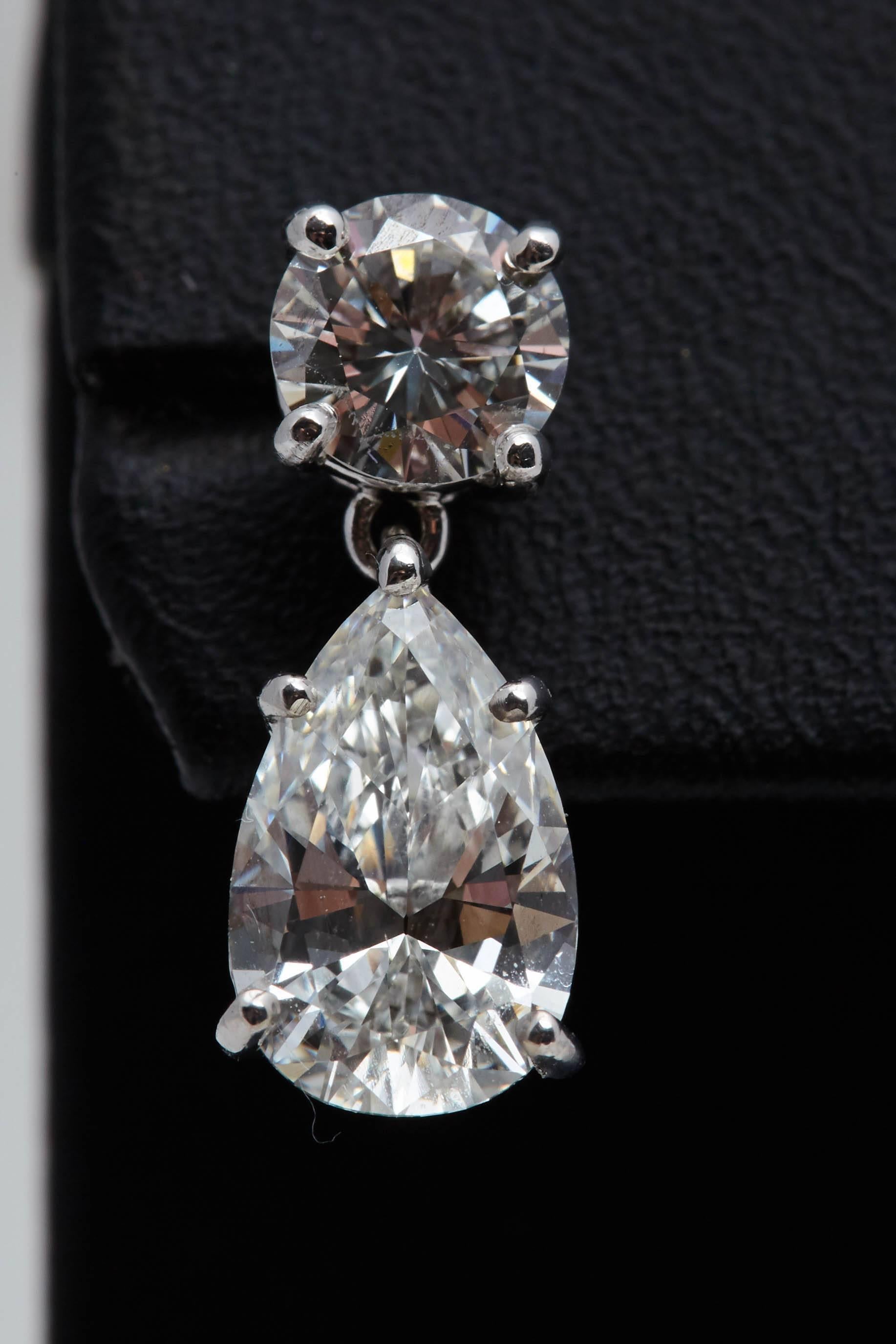 Two pear shaped diamonds with a total weight of 3.08 carats. The pear shaped diamonds are suspended from two round diamonds weighing approximately 1.20 carats. The pear shaped diamonds have certificates from the Gemological Institute of America
