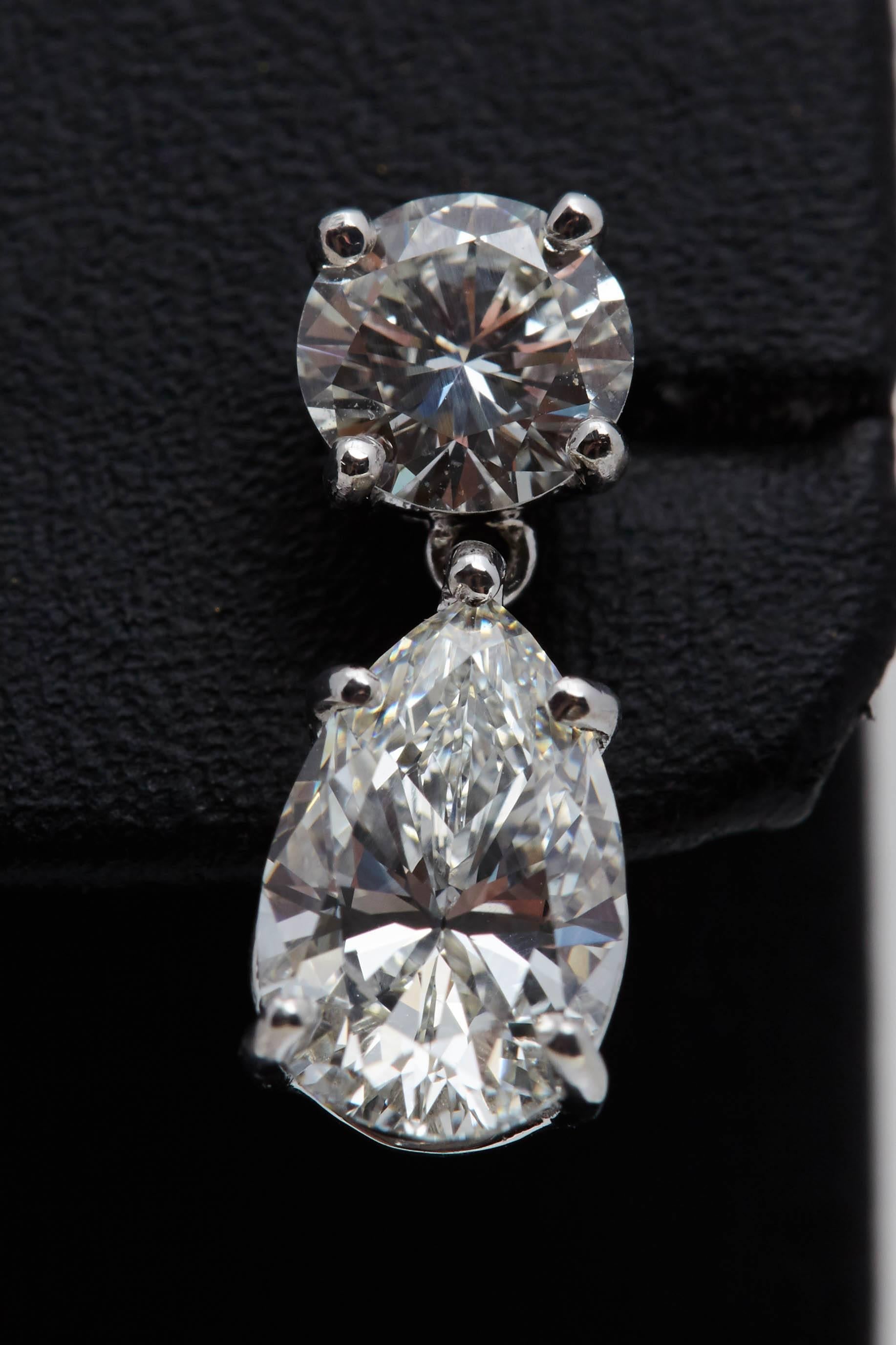 Modern 3.08 Carat Dangling GIA Pear Shaped Platinum Earrings with Two Round Diamonds For Sale