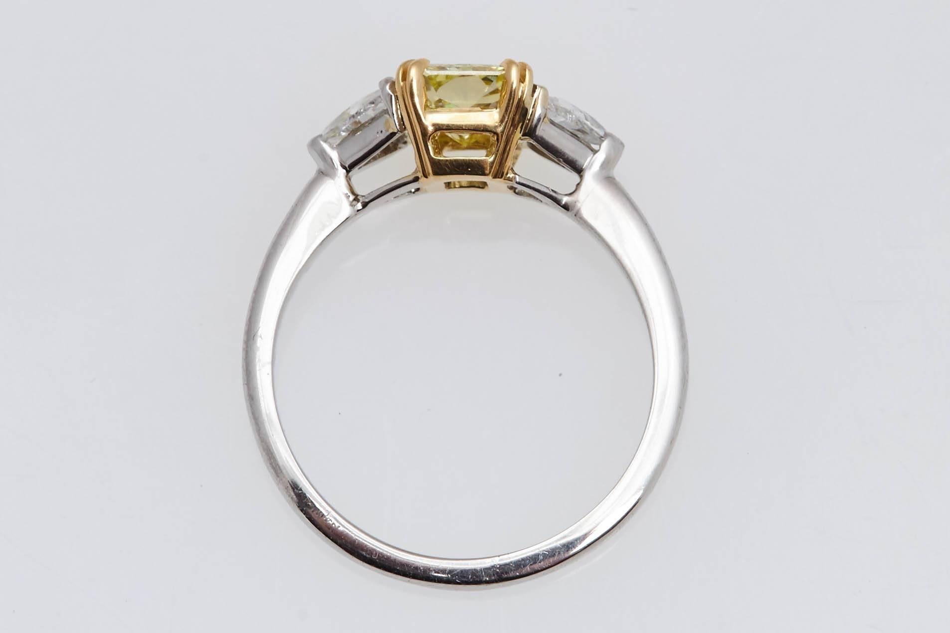 Classic platinum and eighteen karat yellow gold ring with a radiant cut diamond in the center weighing .97 carat. The ring has two trillion shaped diamonds on the side with an approximate weight of .60 carat. The center diamond has a report from the