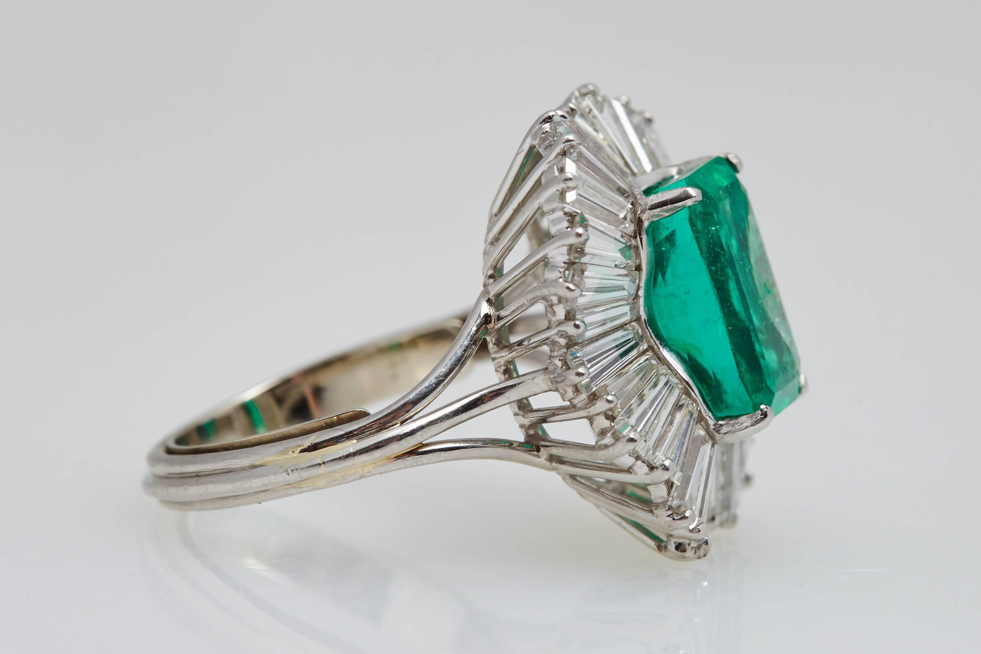A Columbian emerald weighing 5.42 carats surrounded by approximately 3.50 carats of tapered baguette shaped diamonds mounted in a platinum ring. The emerald measures 12.3 mm. in length and 7.8 mm. in width. The ring is a size 8 1/2 and can be