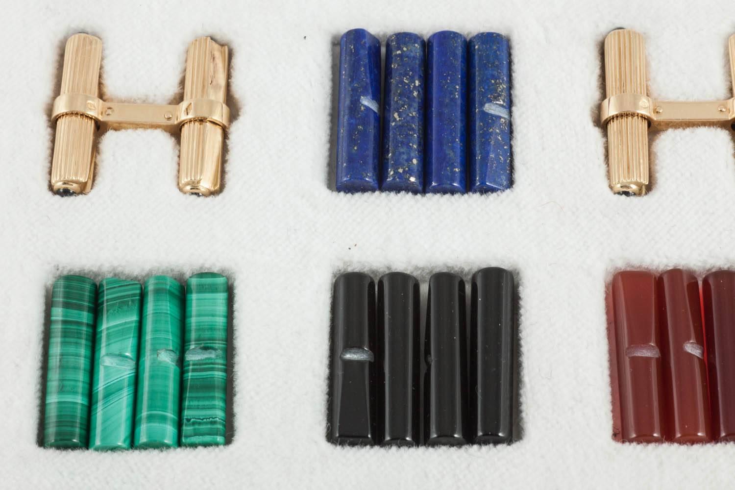 A fine  quality assorted set of coloured batons made by Cartier in a fitted case, with  Gold fluted batons each with a cabochon shaped sapphire terminal, with natural coloured onyx, lapis lazuli, crystal, tigers eye, malachite,coral, cornelian.