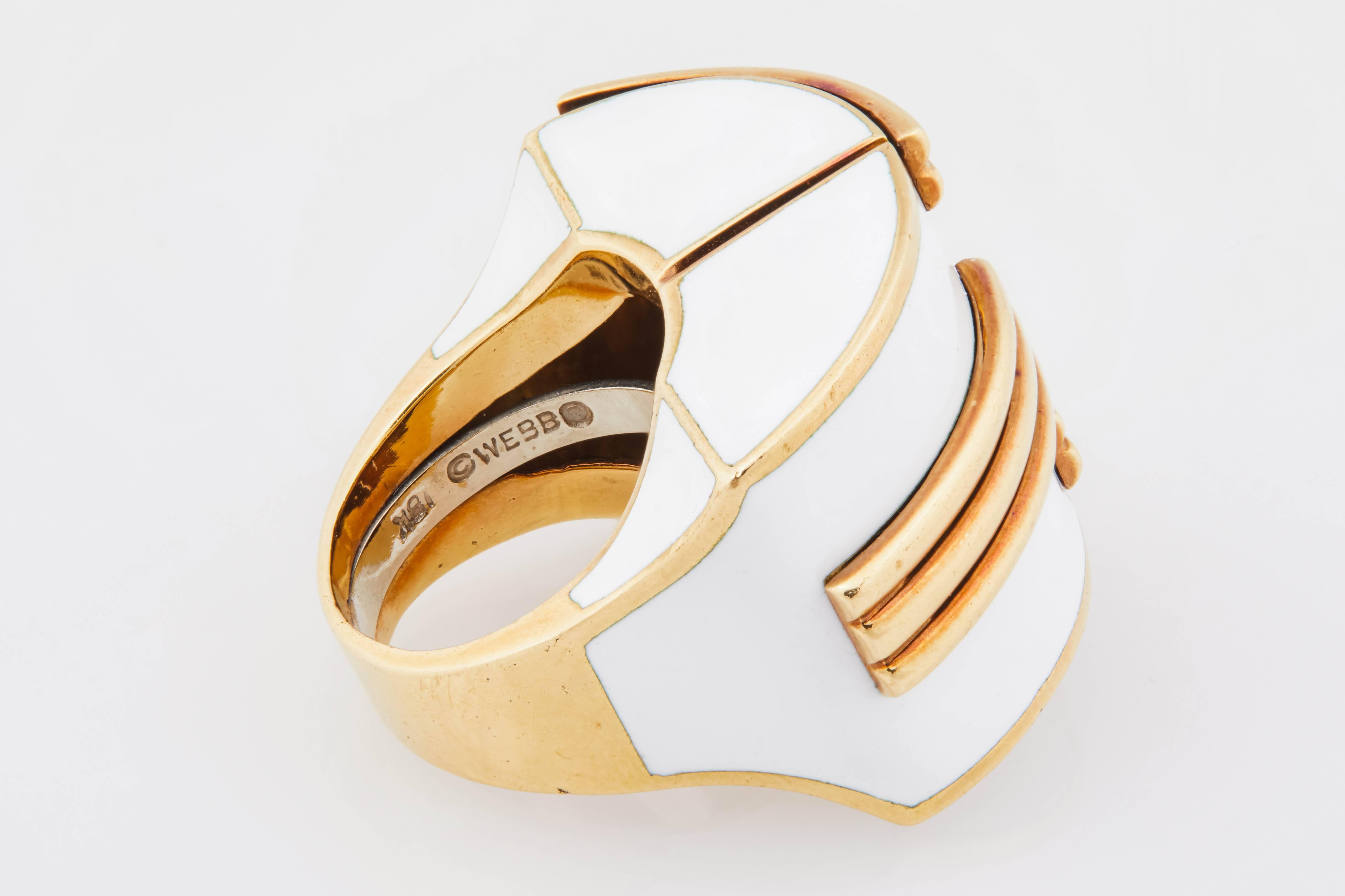 This oversize 18k gold and white enamel David Webb ring is signed and features a raised pavilion, creating the illusion of 3-D and movement. Inside of ring has a spring ring guard for a secure fit on the finger. Size 6. Circa 1970. 