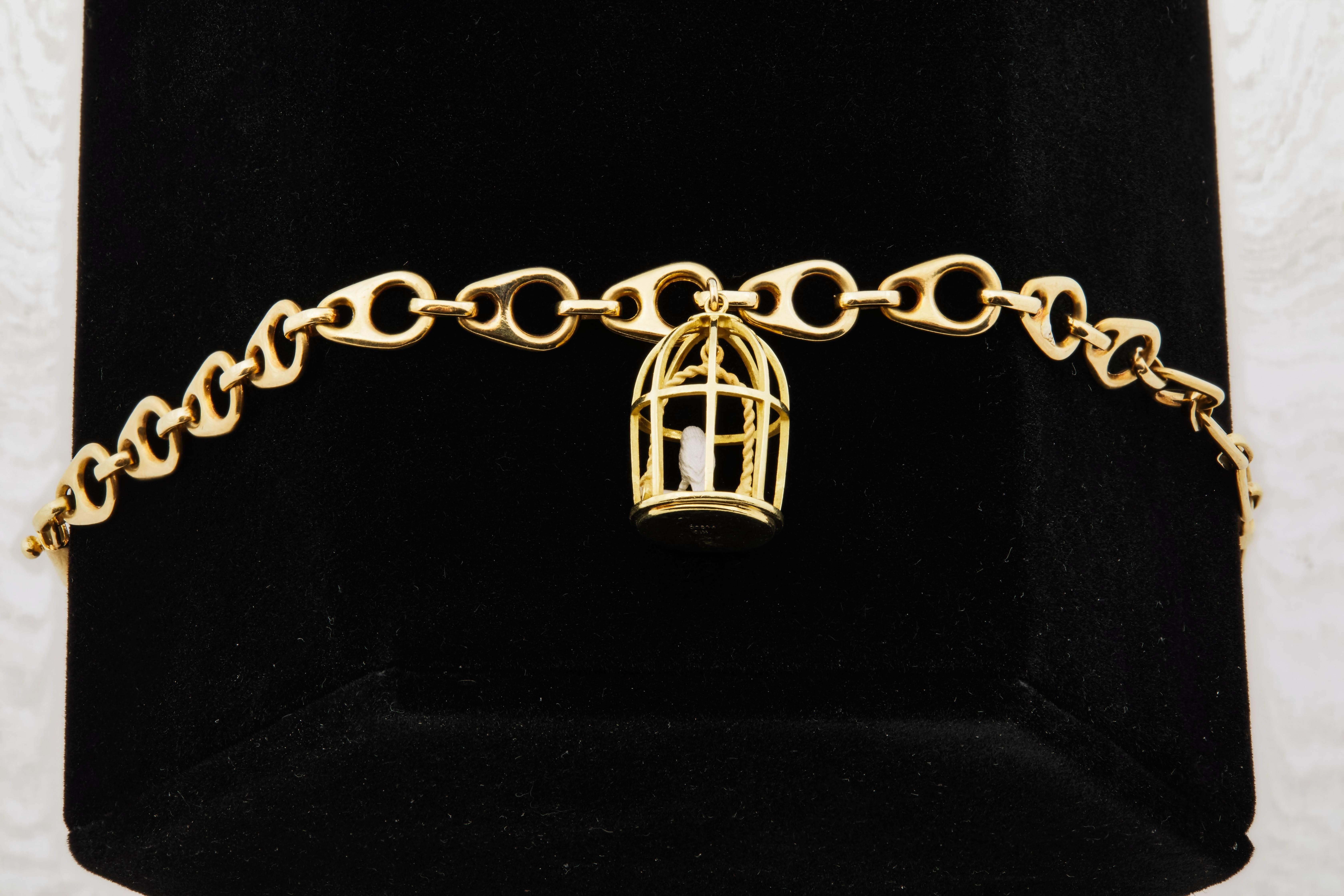 1960s French anchor link 18k gold bracelet, with 18k gold birdcage charm (with bird). Birdcage charm measures 17.5mm H x 11.6mm W.
