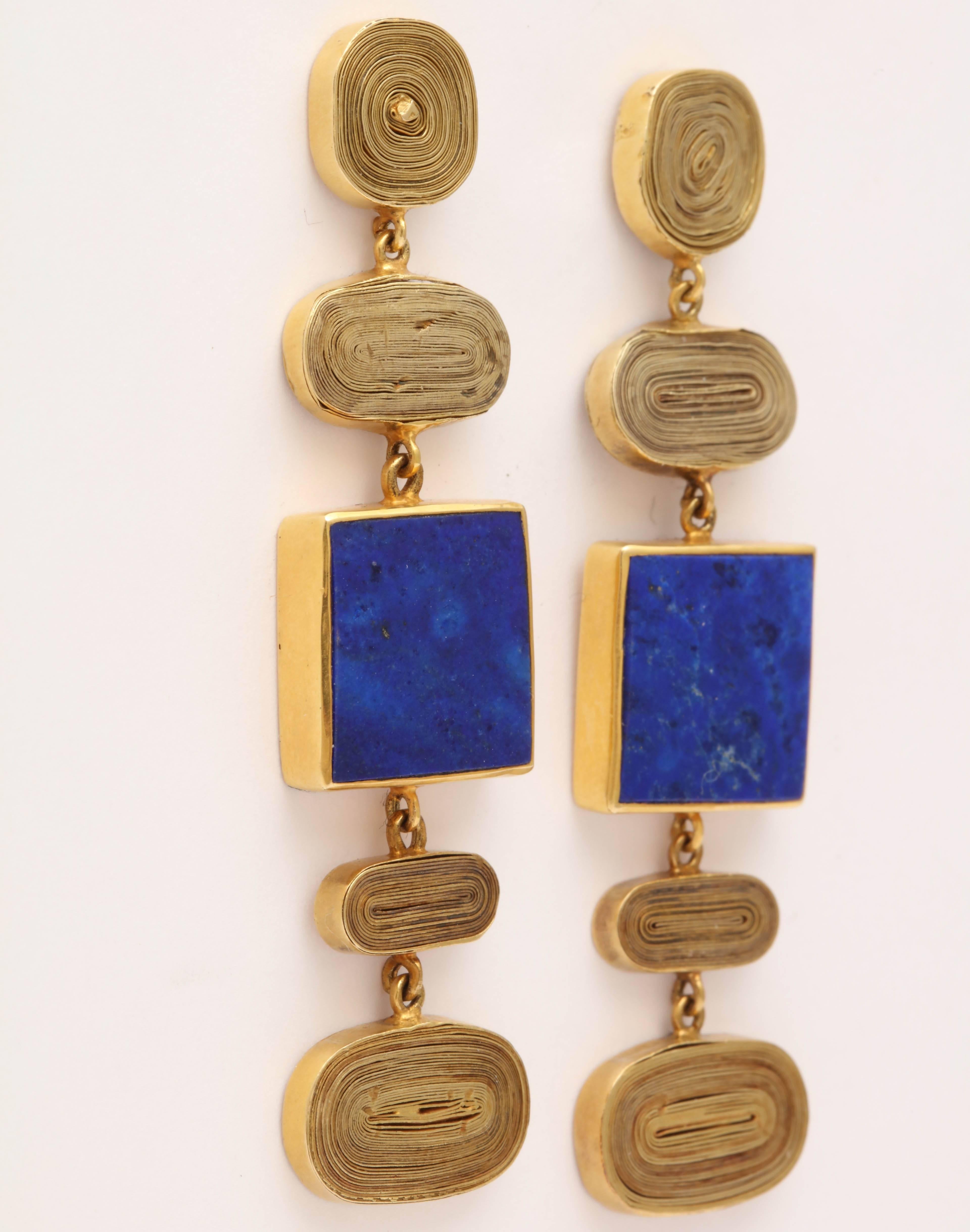 A pair of 18kt yellow gold and lapis lazuli pendant earrings. The earrings are composed of coiled gold plaques and bezel set square lapis lazulis plaques 

Length: 2.35 inches
Width: .55 inch