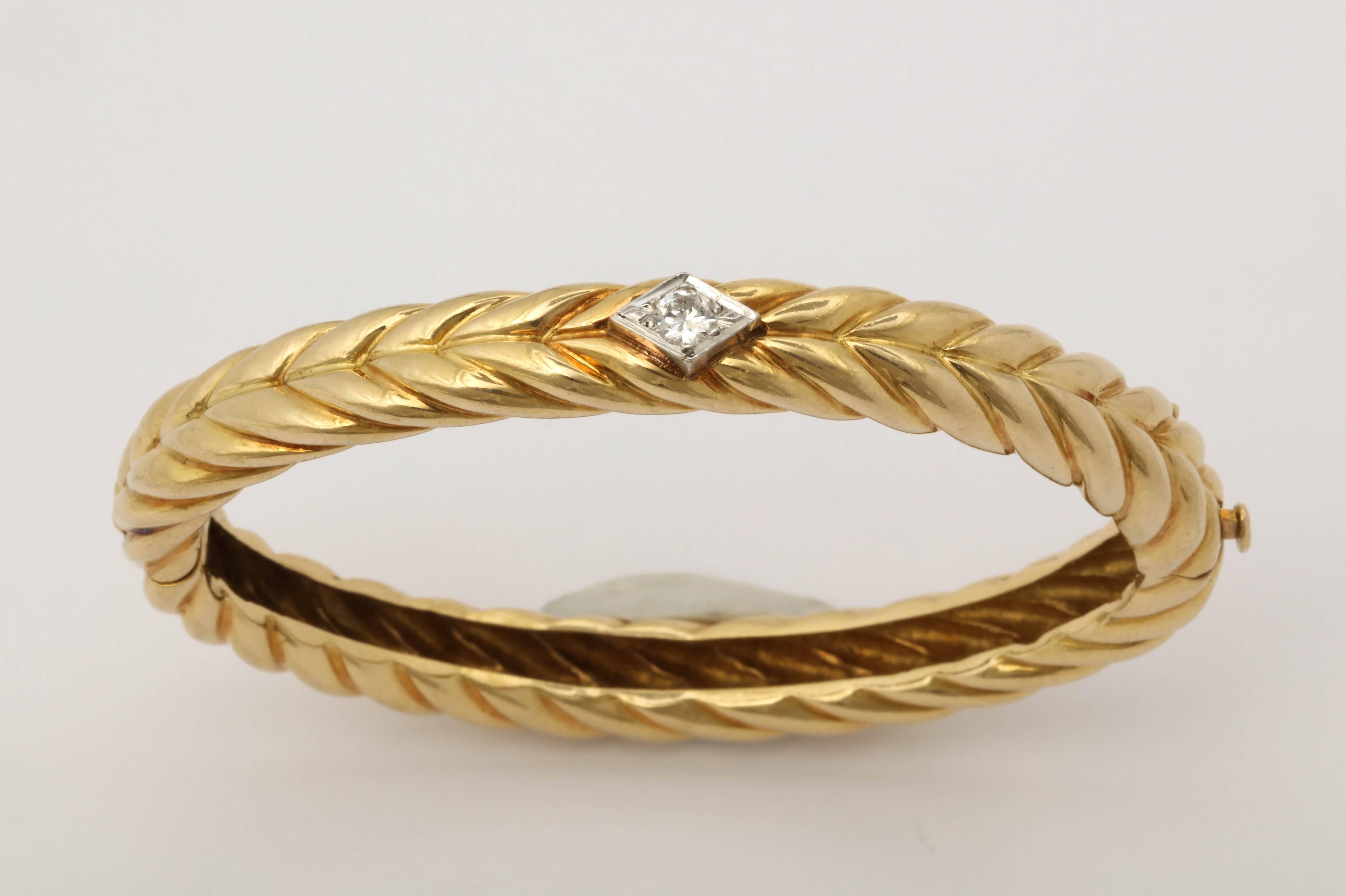 One Ladies 18kt Yellow Gold High Polish Textured Ridged Gold Hinged Oval Shaped Bangle Bracelet. Centering An Approximate .25ct Full Cut Diamond. Bangle Fits An average To Small Size Wrist. Signed And Numbered Cartier, 18kt.Serial # 90032.Attached