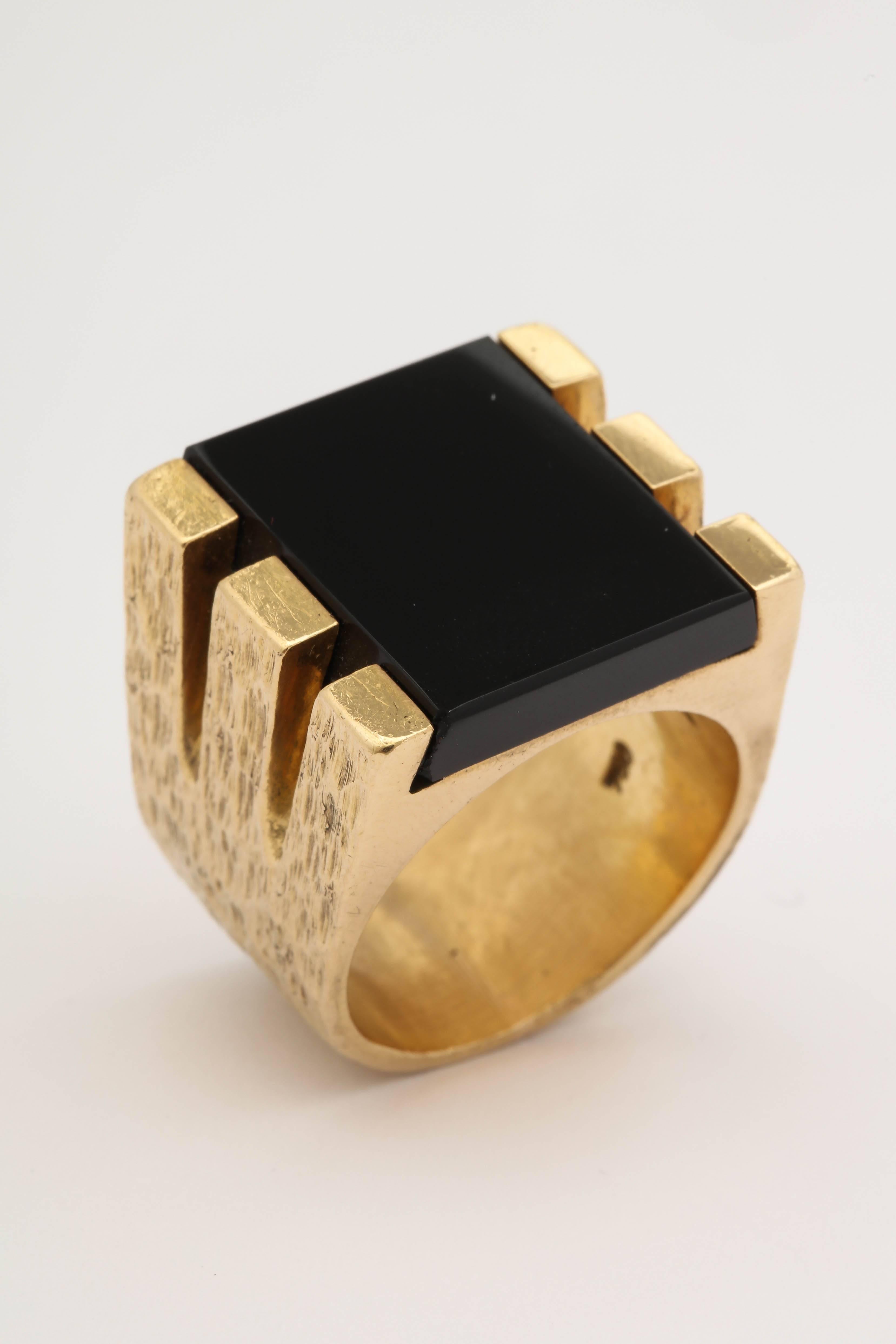 One Unisex Large 18kt Textured Gold Ring Cenering A 22mm Square Cut Onyx stone. Onyx Is Beautifully Set In A Heavy Six Prong Bar Structure.Ring Is Stamped 750 For a European 18kt Gold Marking. Designed In The 1970's With An Unrecognizable Makers