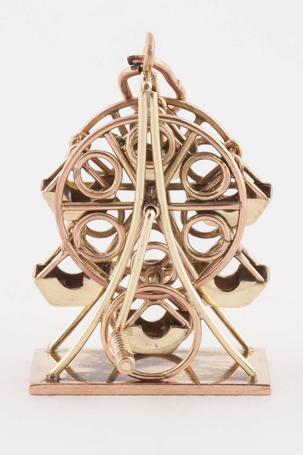 Reminiscent of Vienna’s Riesenrad in The Third Man (1949) this two color gold Ferris wheel miniature, from the 1950s, revolves by way of a crank, its chairs swinging as it turns around, on a flat base, it may be worn as a pendant or simply admired