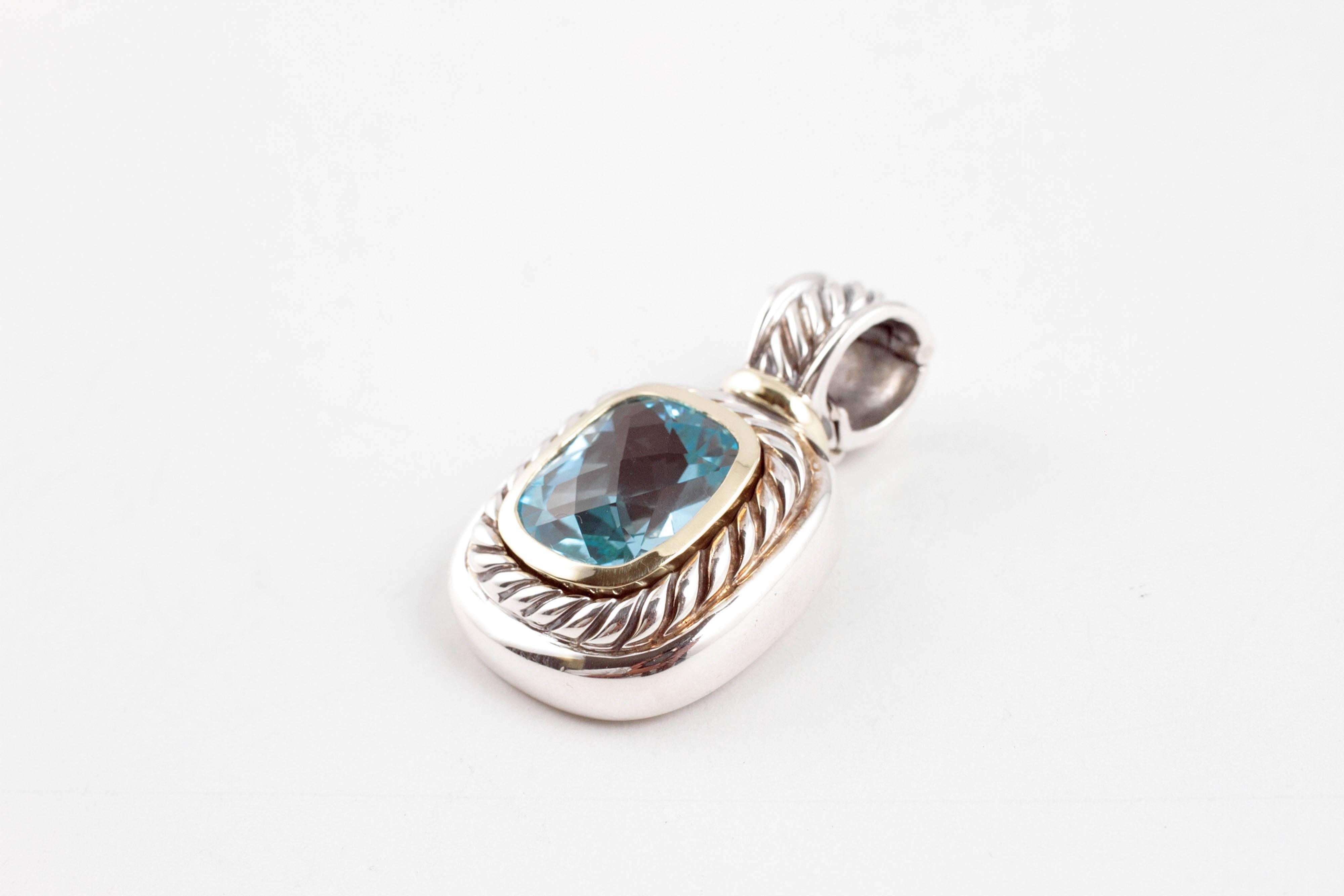 Timeless classic in sterling silver and yellow gold from the Albion line!  This hinged enhancer measures 1.18 inches in length x .63 inches in width and is centered with a striking blue topaz.  