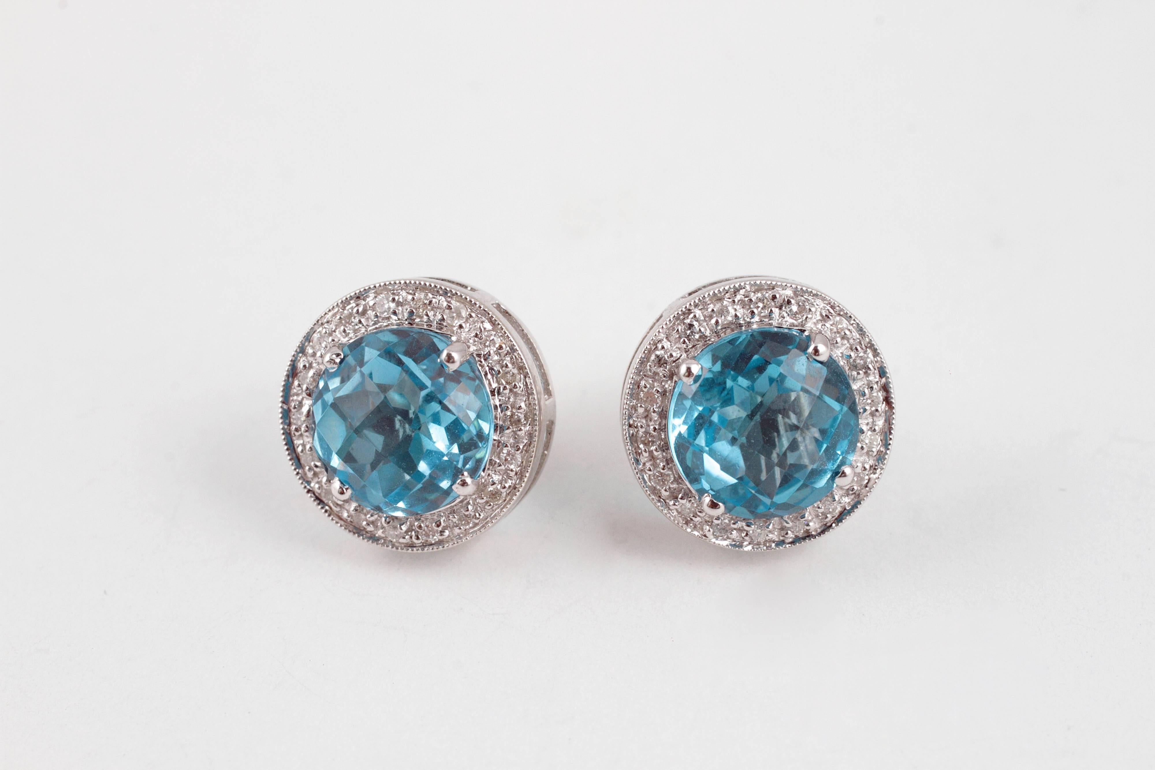 What a pop of color!  Bright blue, round topaz stones surrounded by a row of diamonds, all set in 14 karat white gold, with standard friction backs.  