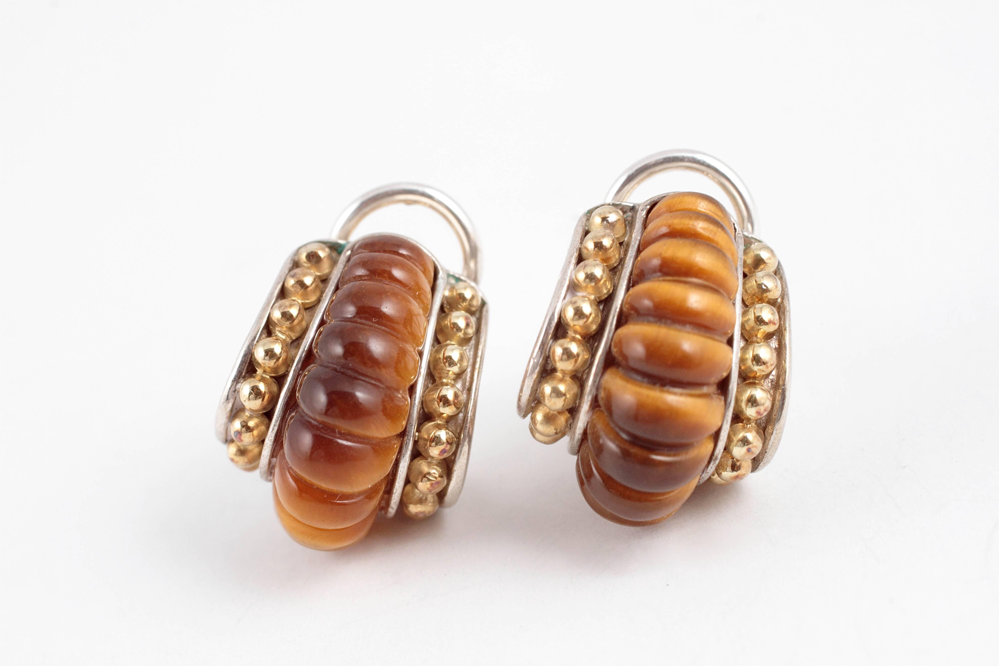 In 18 karat yellow gold and sterling silver.  The beautiful Tigers Eye is in so many shades of brown!  Pierced/clip back.