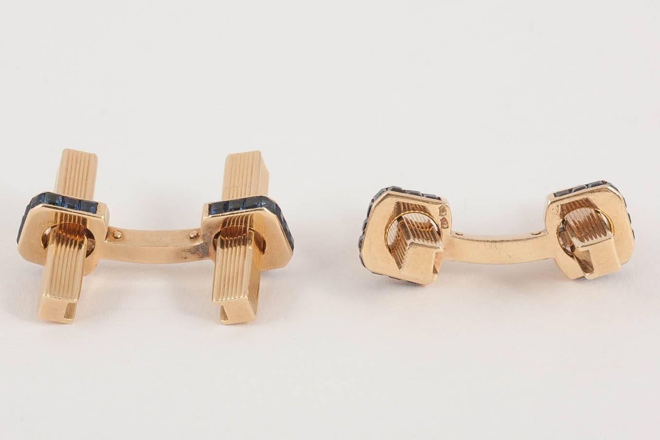 A pair of heavy,and solid baton cufflinks by Boucheron of paris,marked with eagles heads, in 18ct yellow gold,each baton with a surround of eleven,square cut sapphires.c,1950